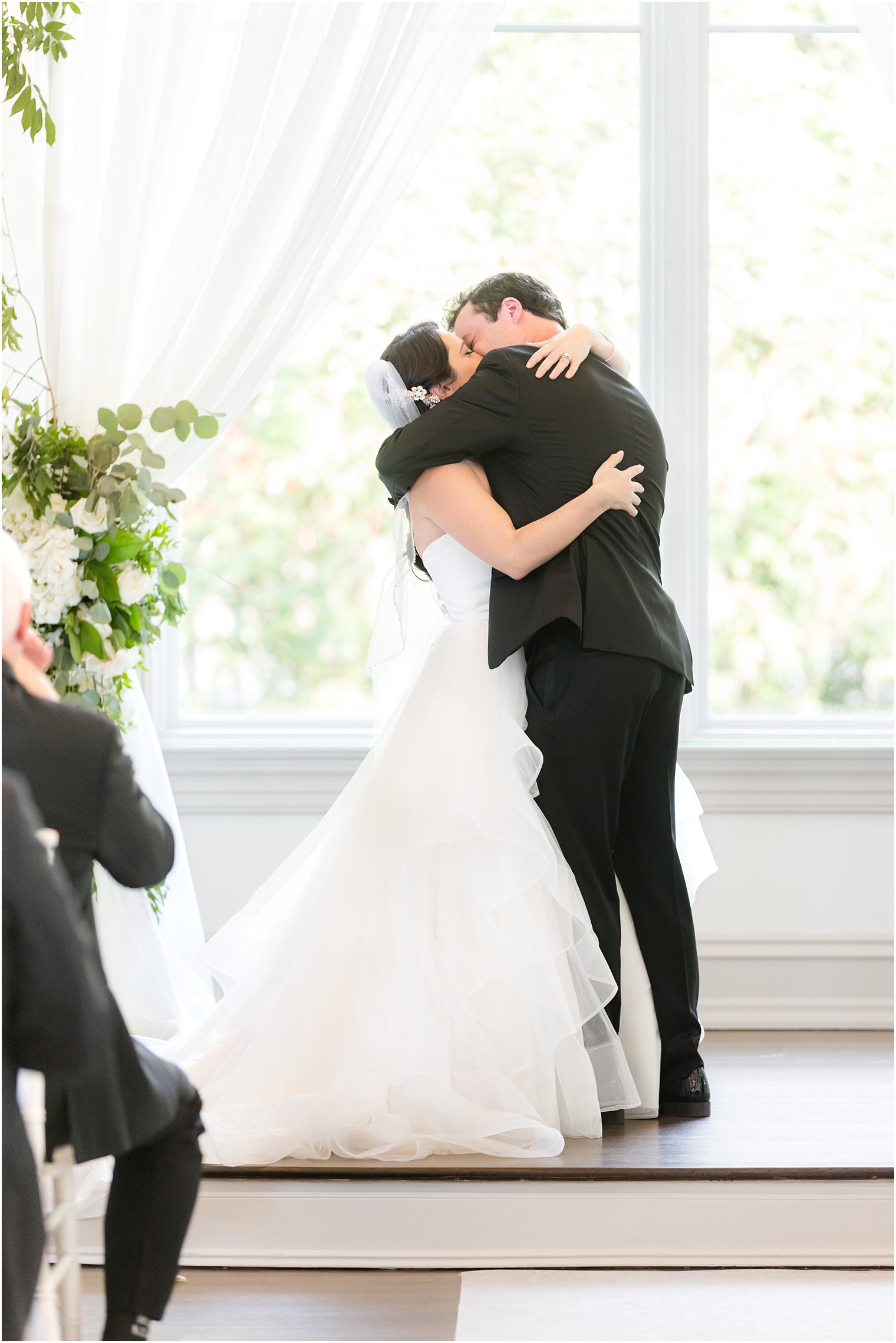 bride and groom hug and kiss during NJ wedding ceremony 