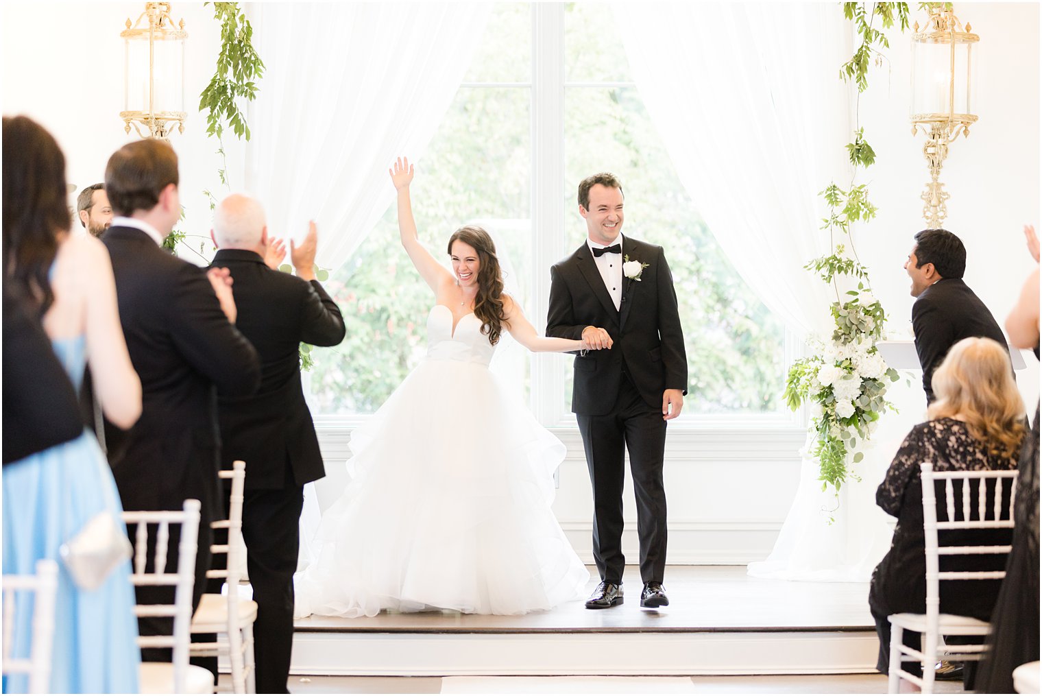 bride throws hand in the air after ceremony