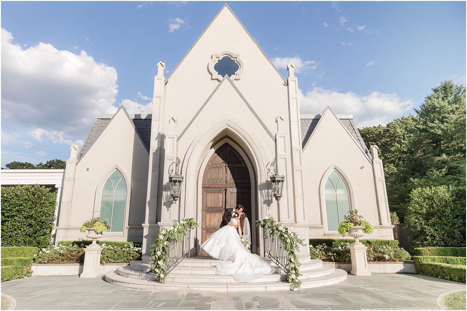 bride and groom kiss on steps of chapel at Park Chateau Estate