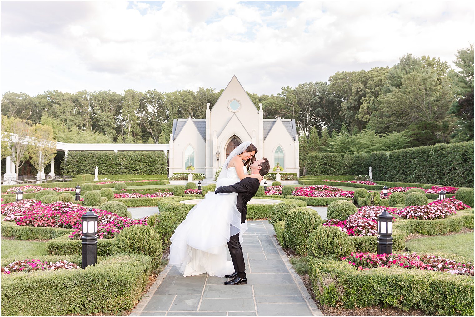 groom lifts bride in gardens of Park Chateau Estate