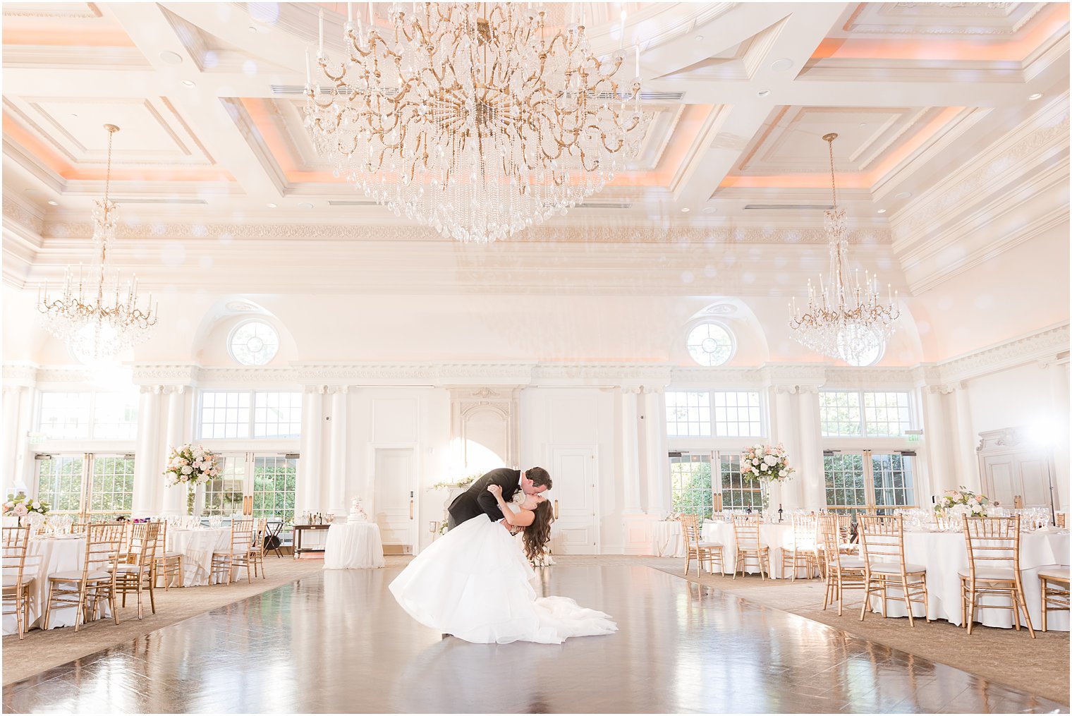 groom dips bride for kiss in ballroom