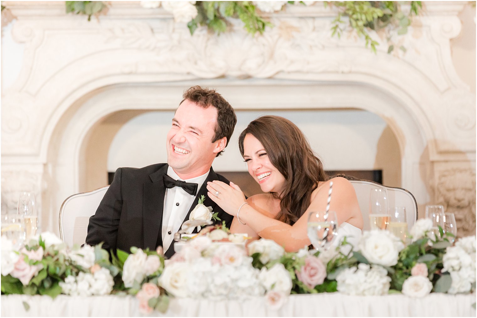 bride and groom laugh together during toasts 