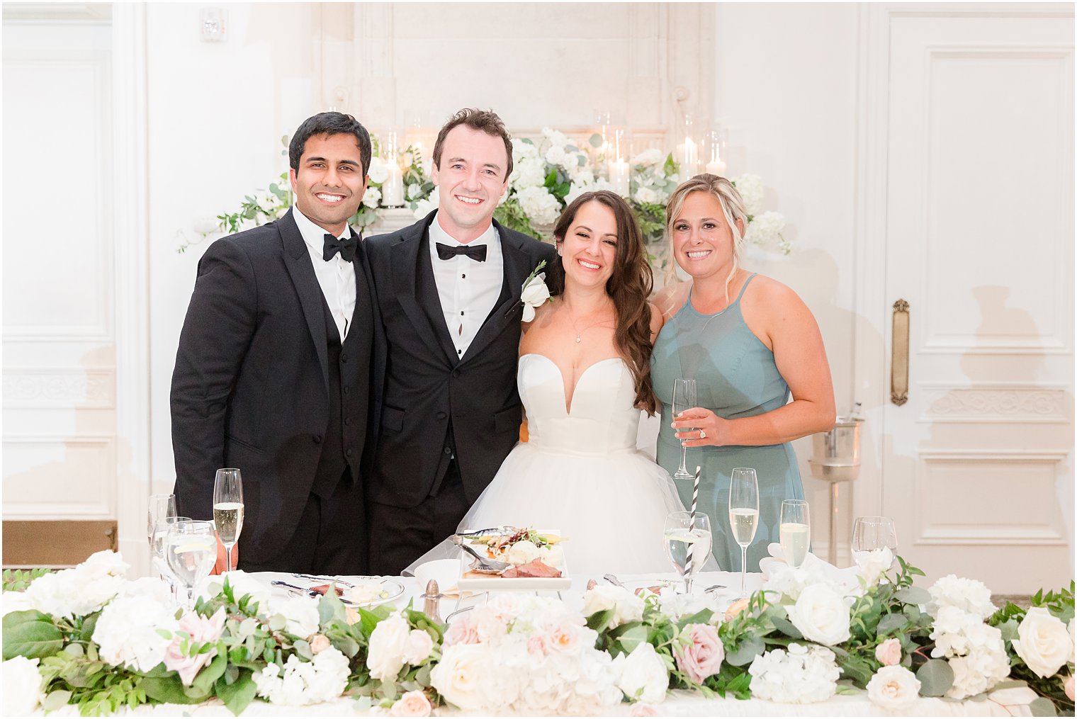  newlyweds pose with maid of honor and best man at sweetheart table 