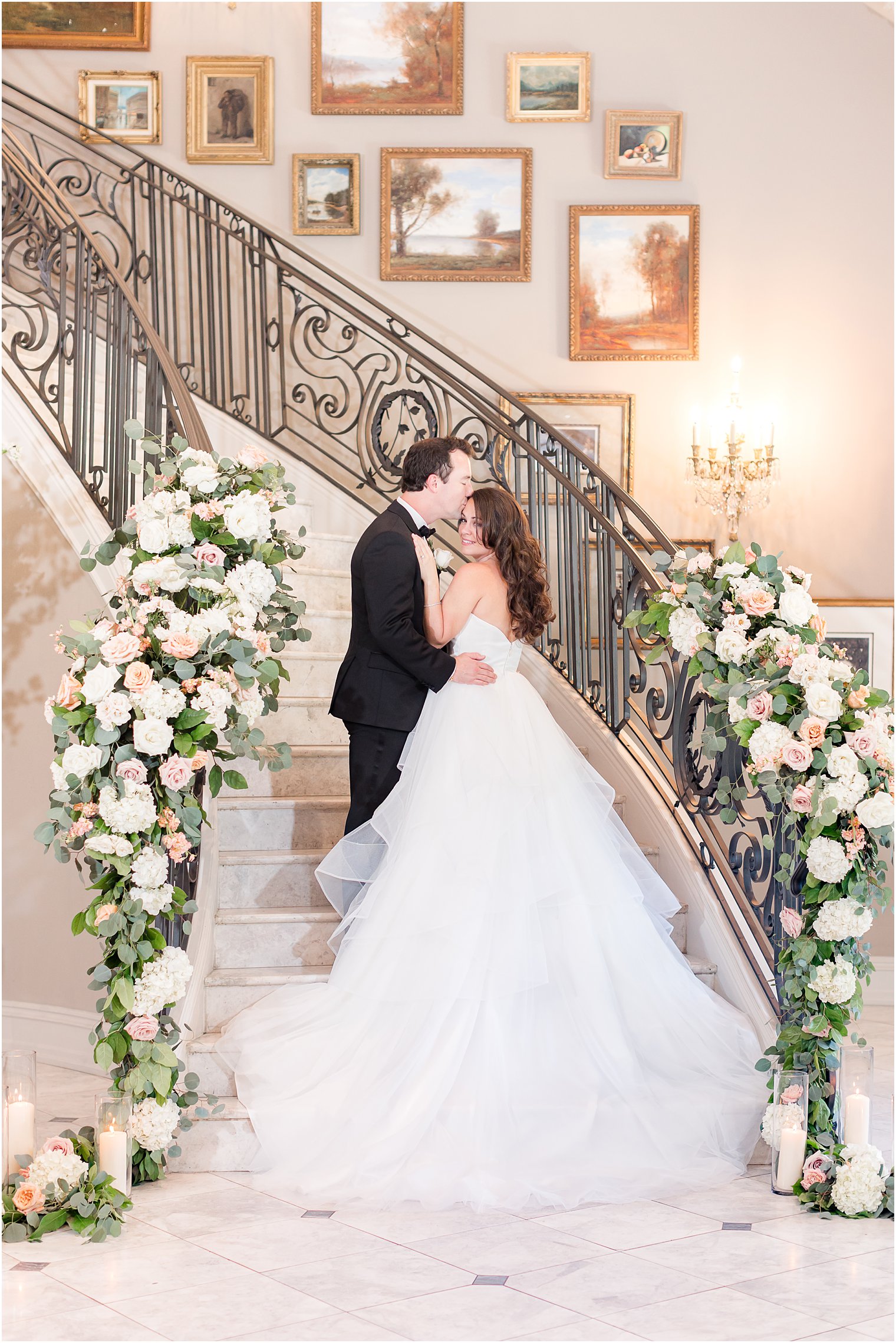groom kisses bride's forehead on staircase at Park Chateau Estate