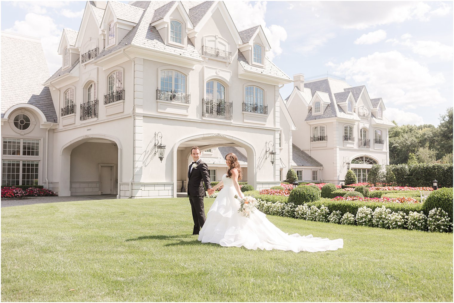 bride and groom hold hands walking through lawn at Park Chateau Estate