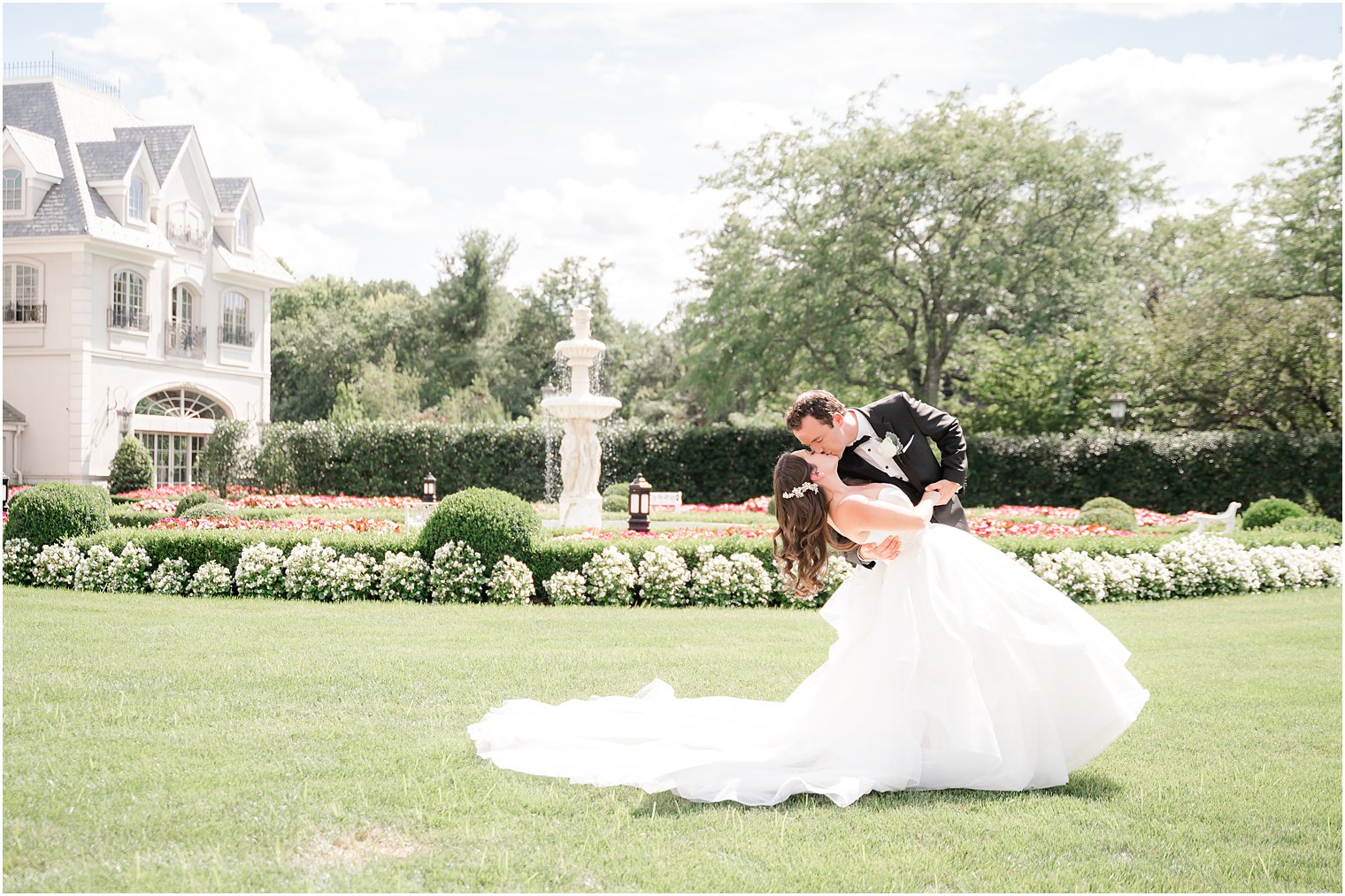 groom dips bride in front of gardens in New Jersey 