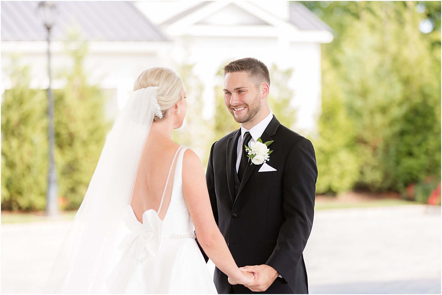 newlyweds stand outsider Shadowbrook at Shrewsbury holding hands during first look