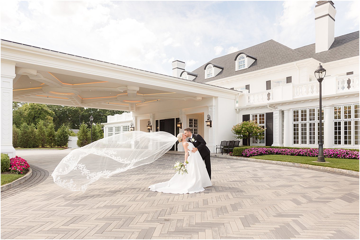 bride and groom kiss with bride's veil floating behind them at Shadowbrook at Shrewsbury