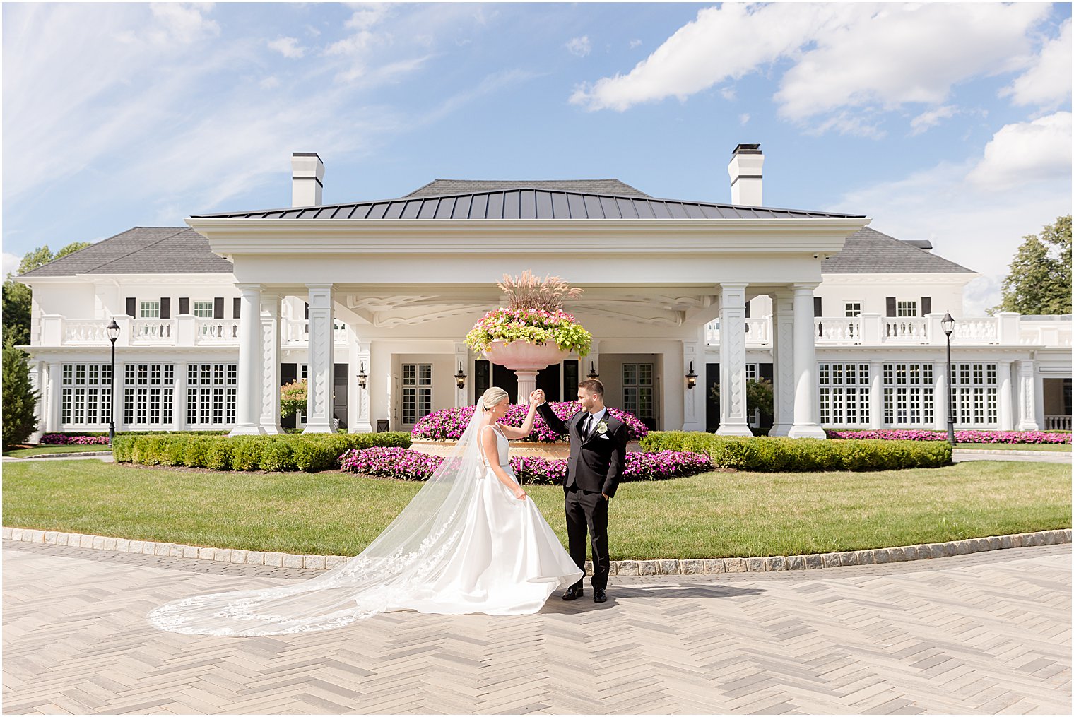 bride and groom hold hands outside fountain in front of Shadowbrook at Shrewsbury