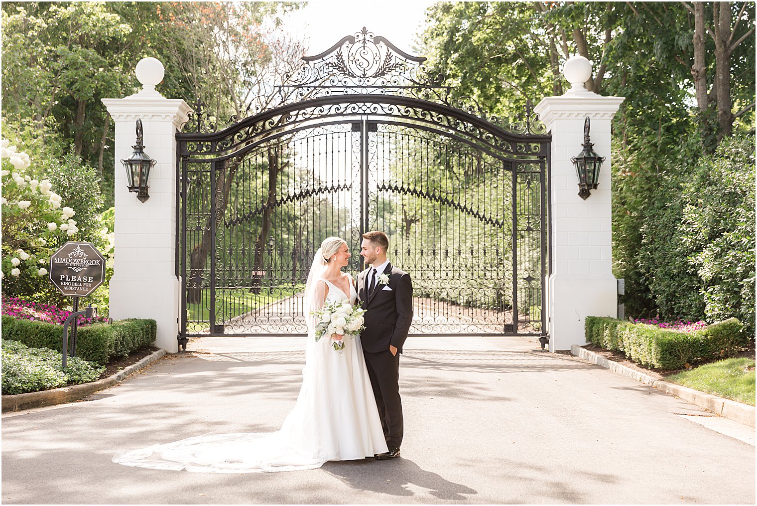 bride and groom hug by wrought iron gate at Shadowbrook at Shrewsbury