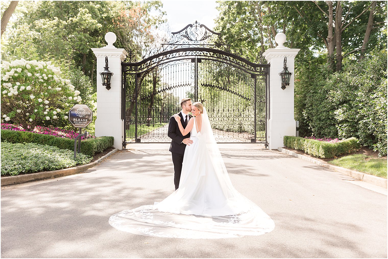 bride and groom hug by front gate at Shadowbrook at Shrewsbury