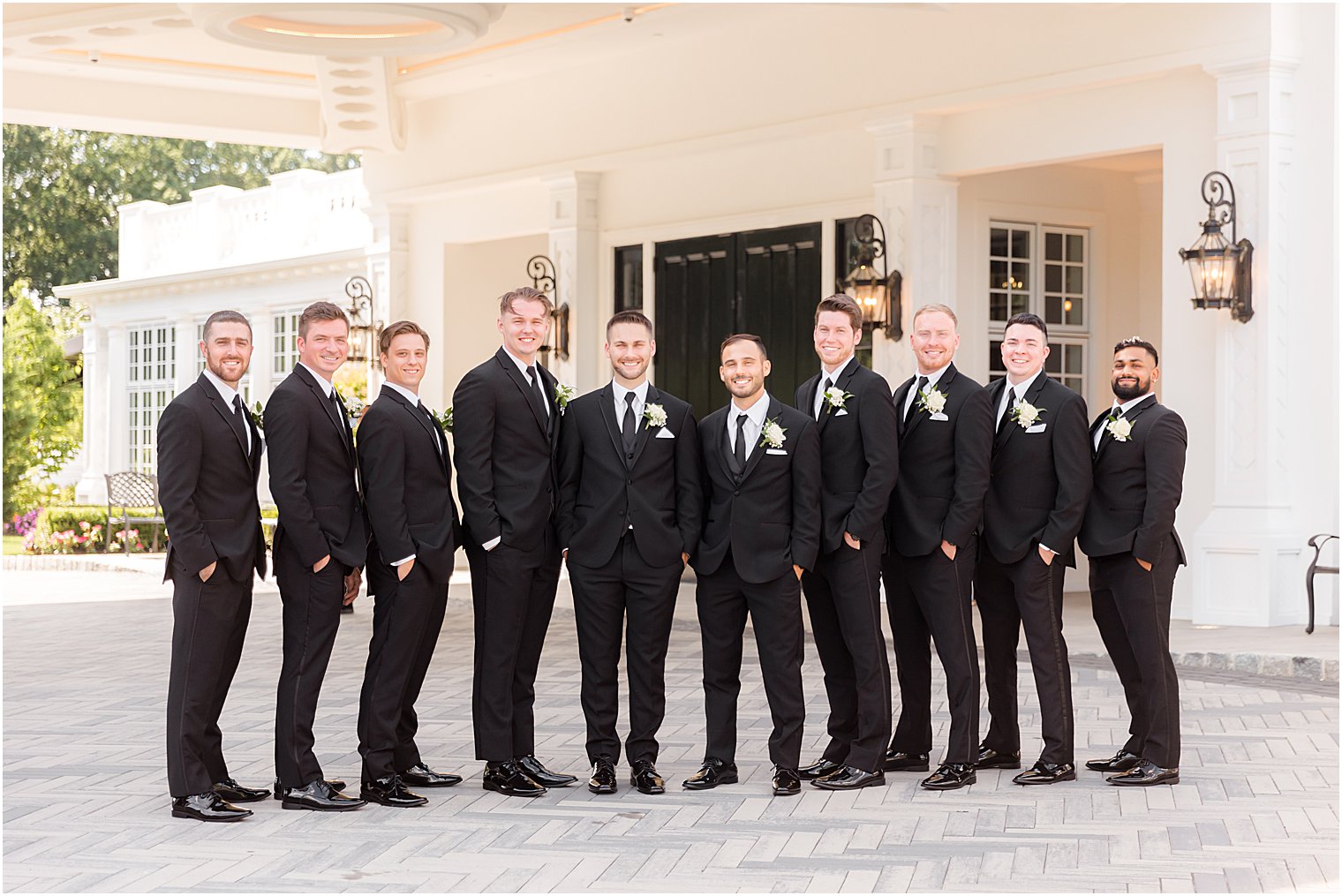 groom and groomsmen stand together in classic tuxes