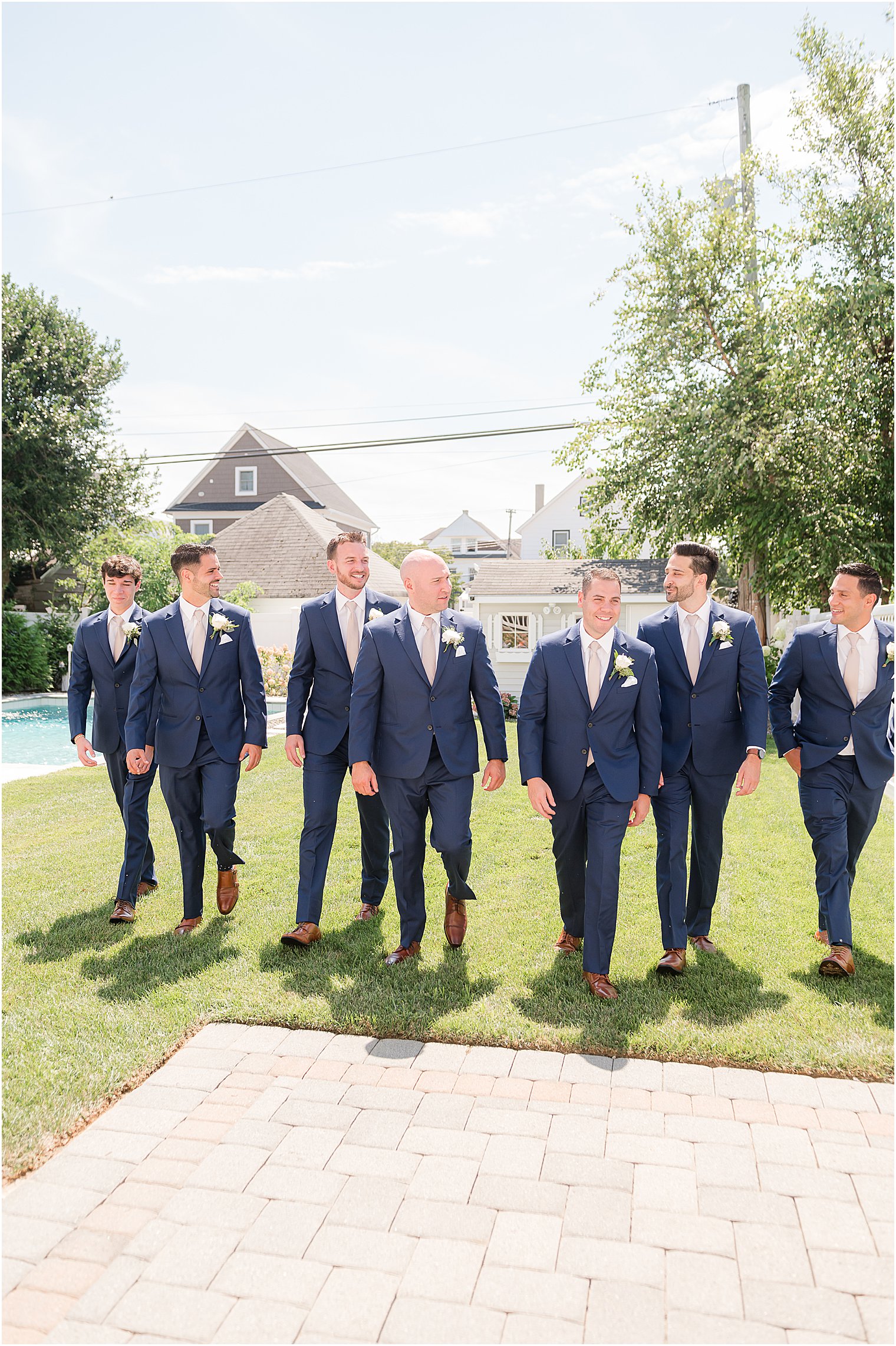 groom walks with groomsmen in navy suits