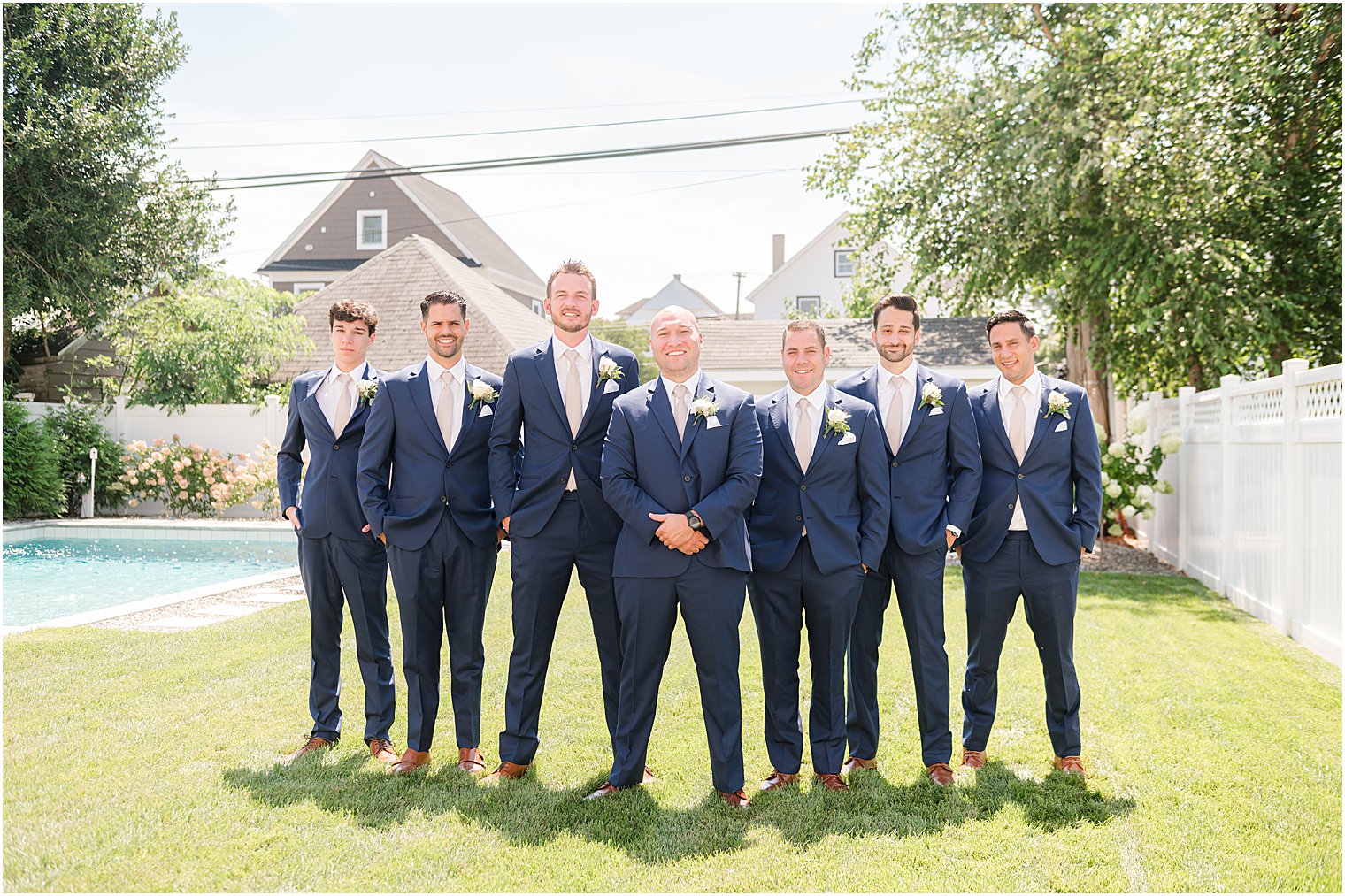 groom and groomsmen stand with navy blue suits