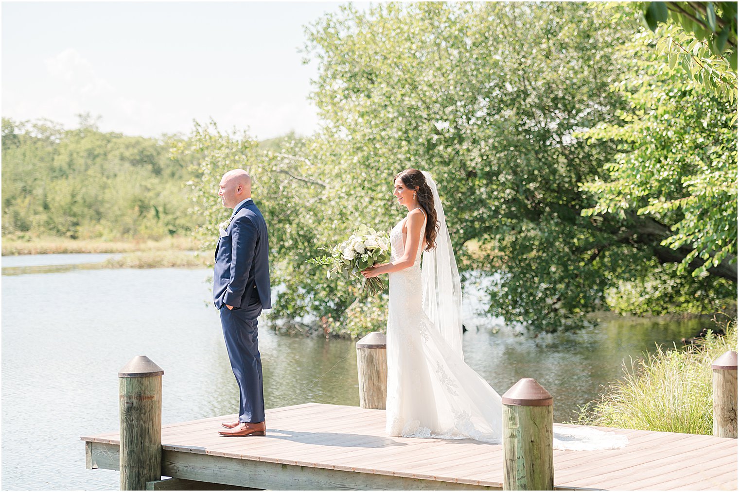 bride walks to groom for first look on dock at The Mill Lakeside Manor