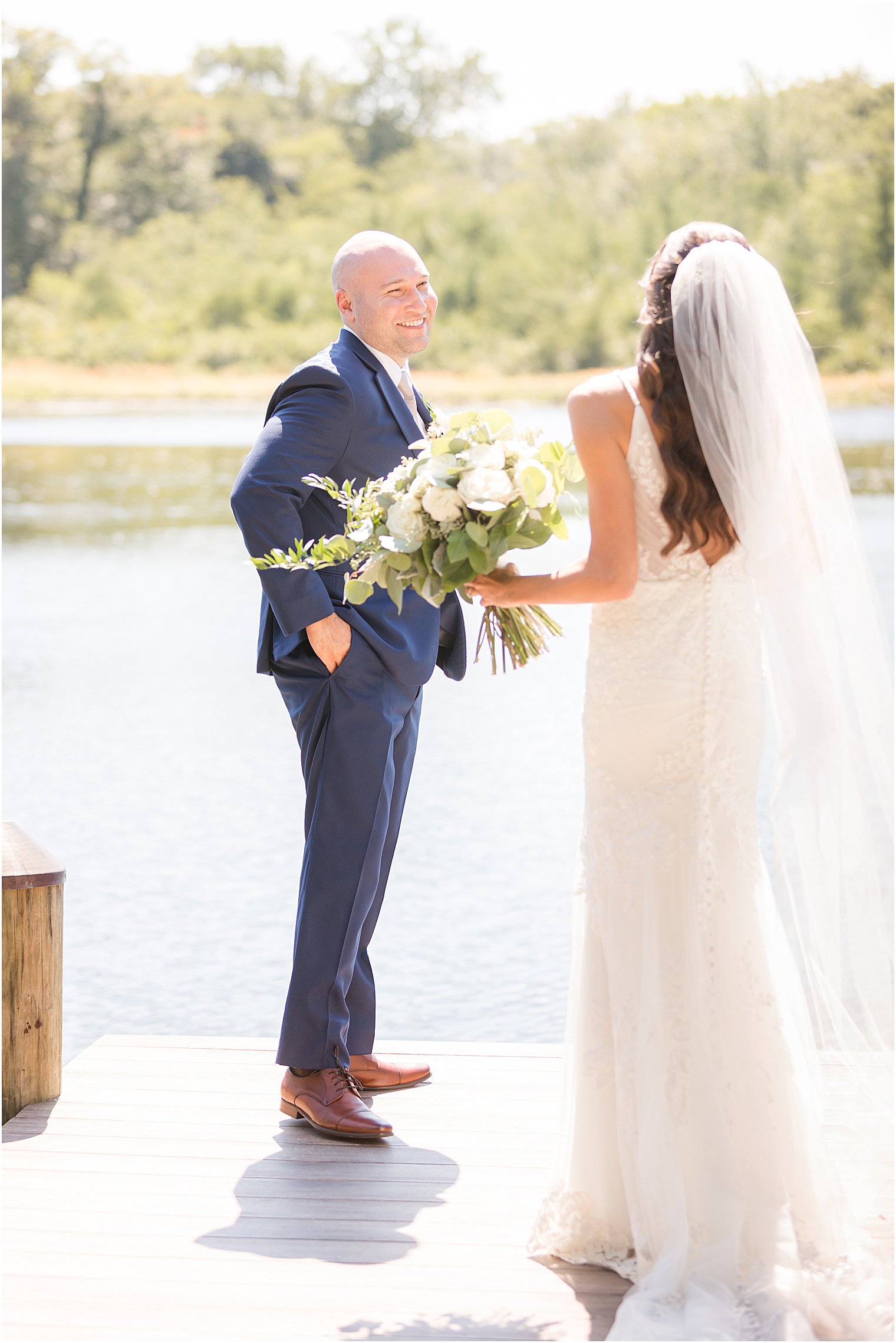 groom smiles at bride during first look at The Mill Lakeside Manor