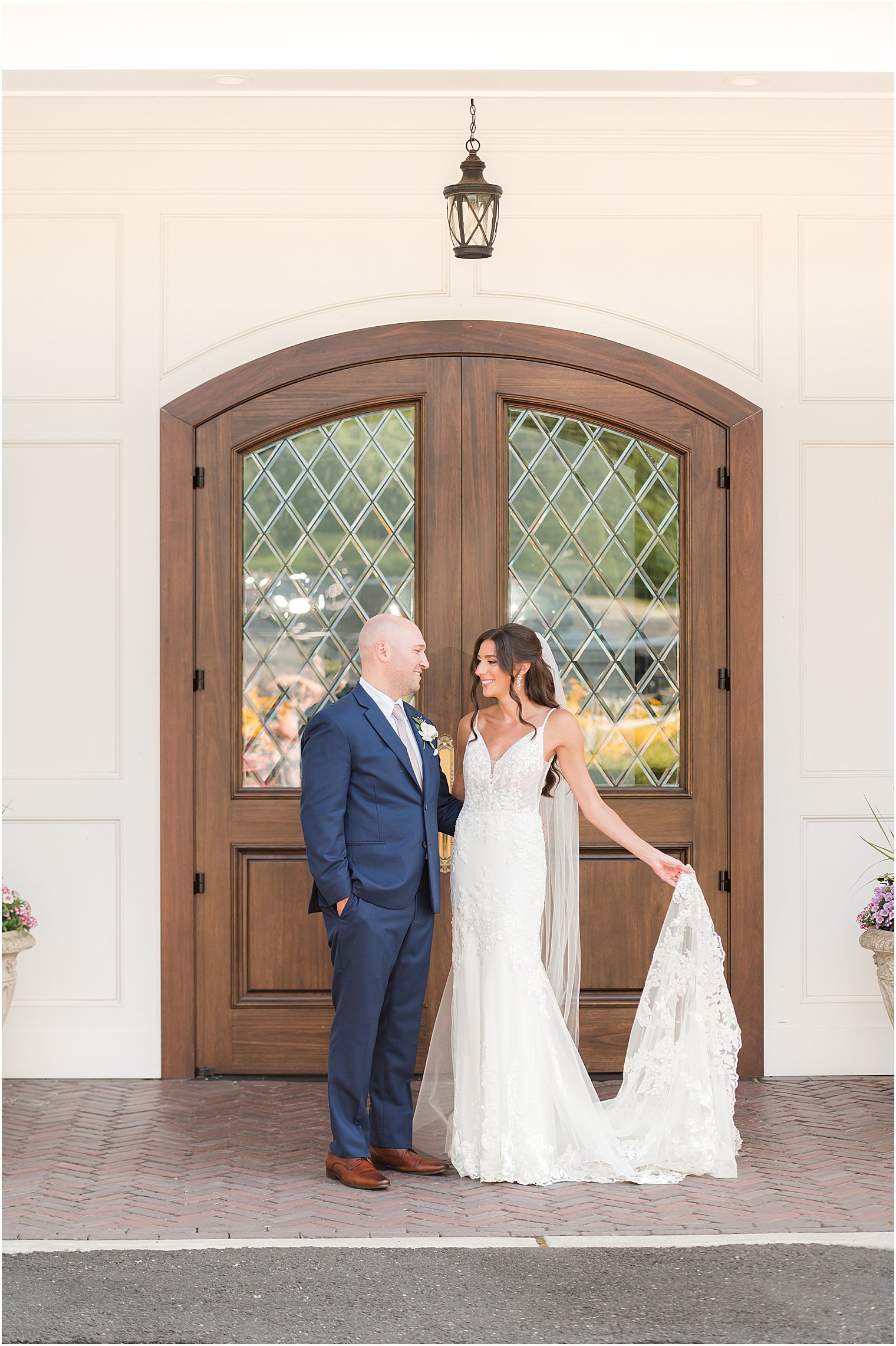 bride and groom pose by wooden doors in New Jersey