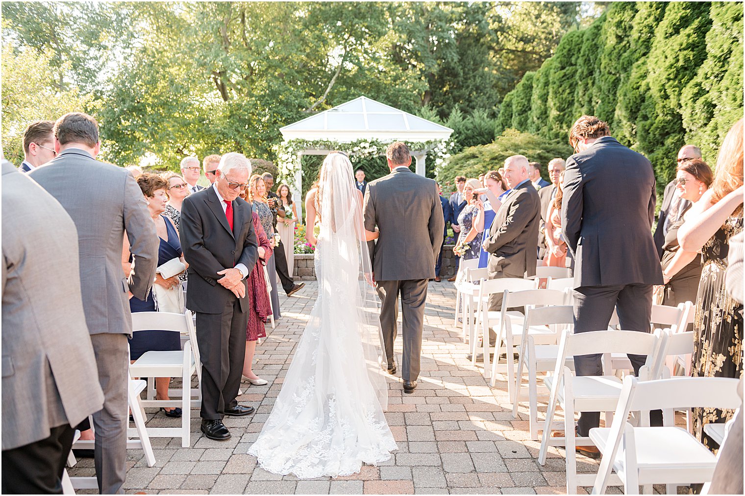 bride and father walk down aisle during outdoor ceremony at The Mill Lakeside Manor