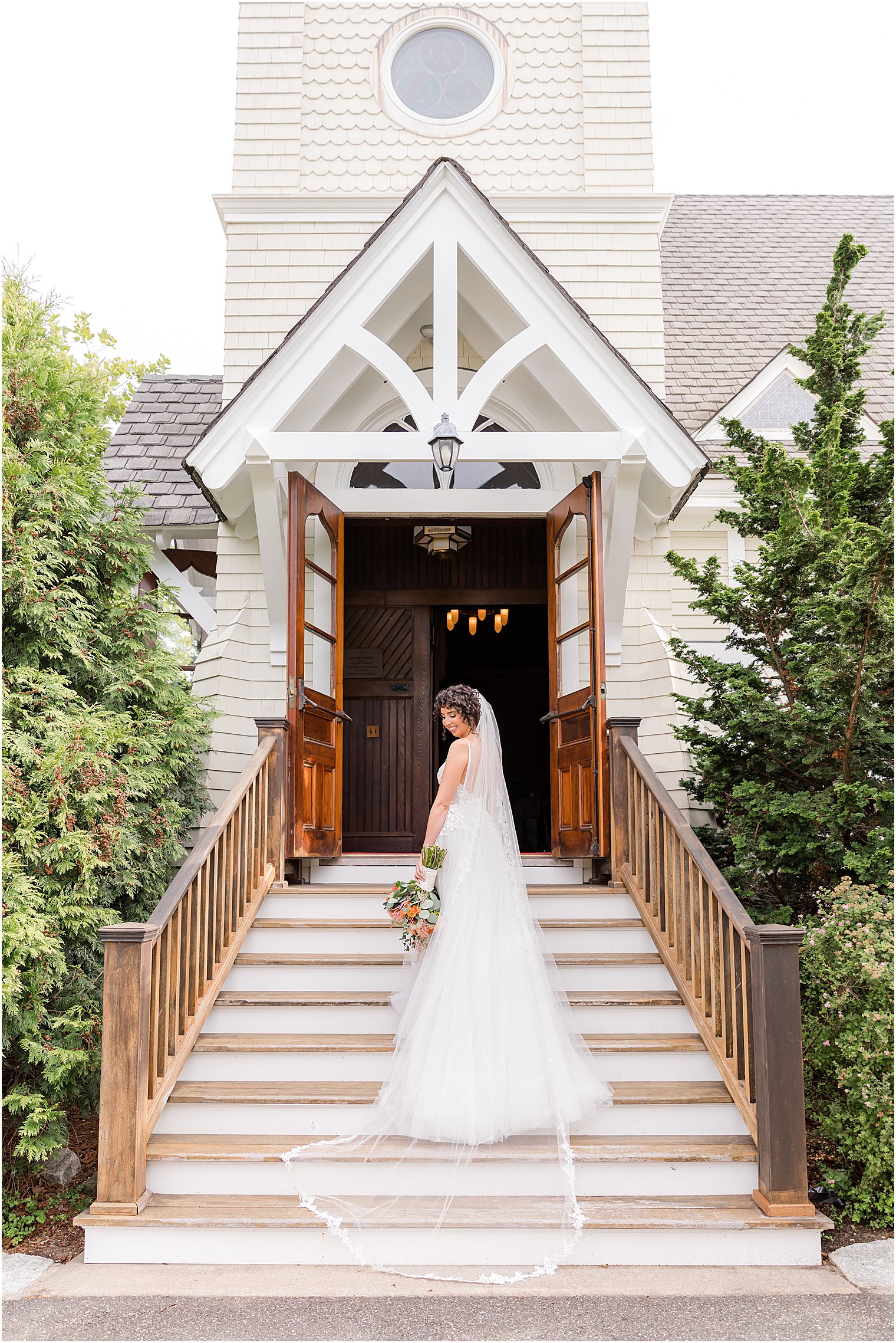 bride poses on steps of methodist church in Spring Lake NJ