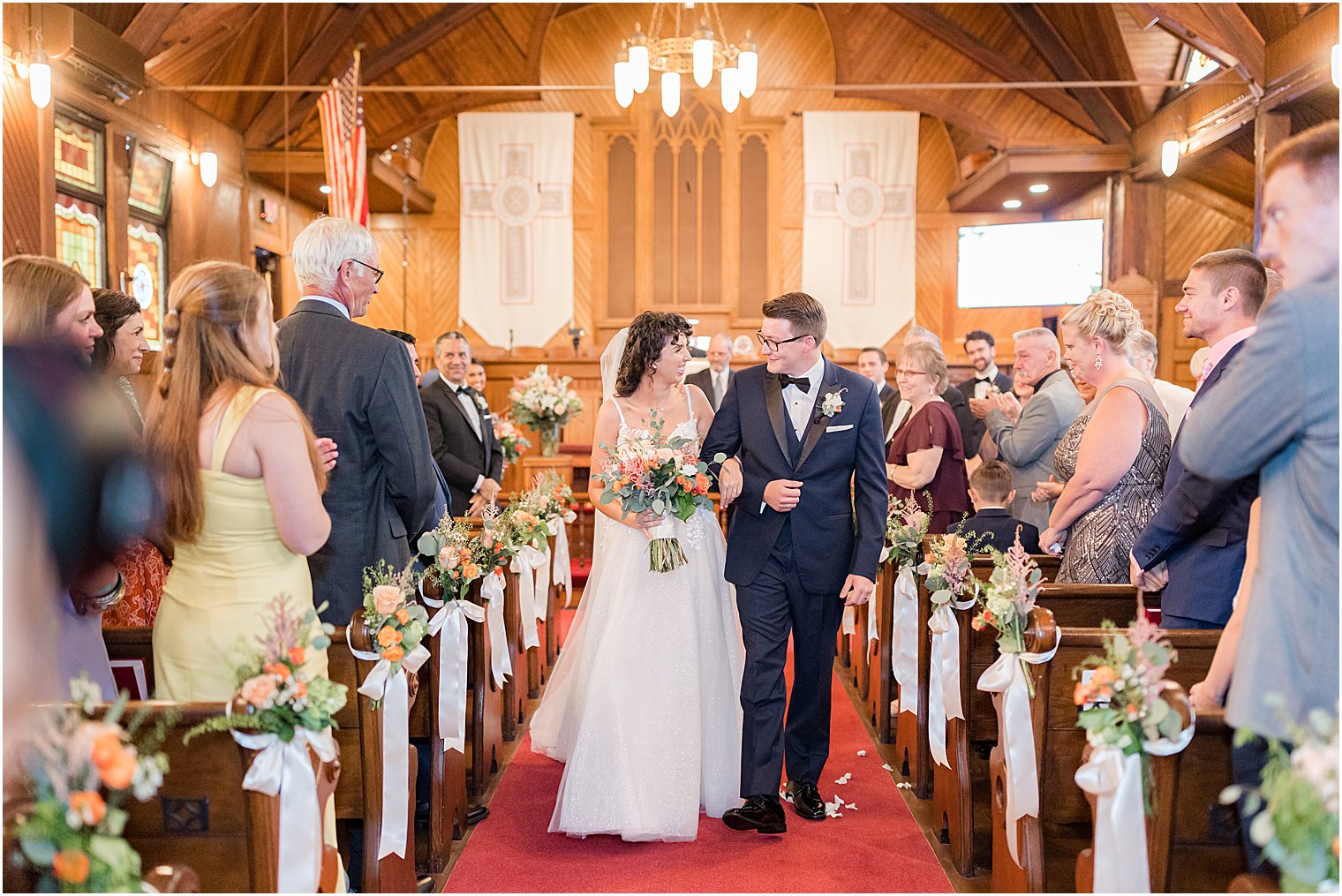 newlyweds walk up aisle at wedding ceremony at St. Andrew's United Methodist Church