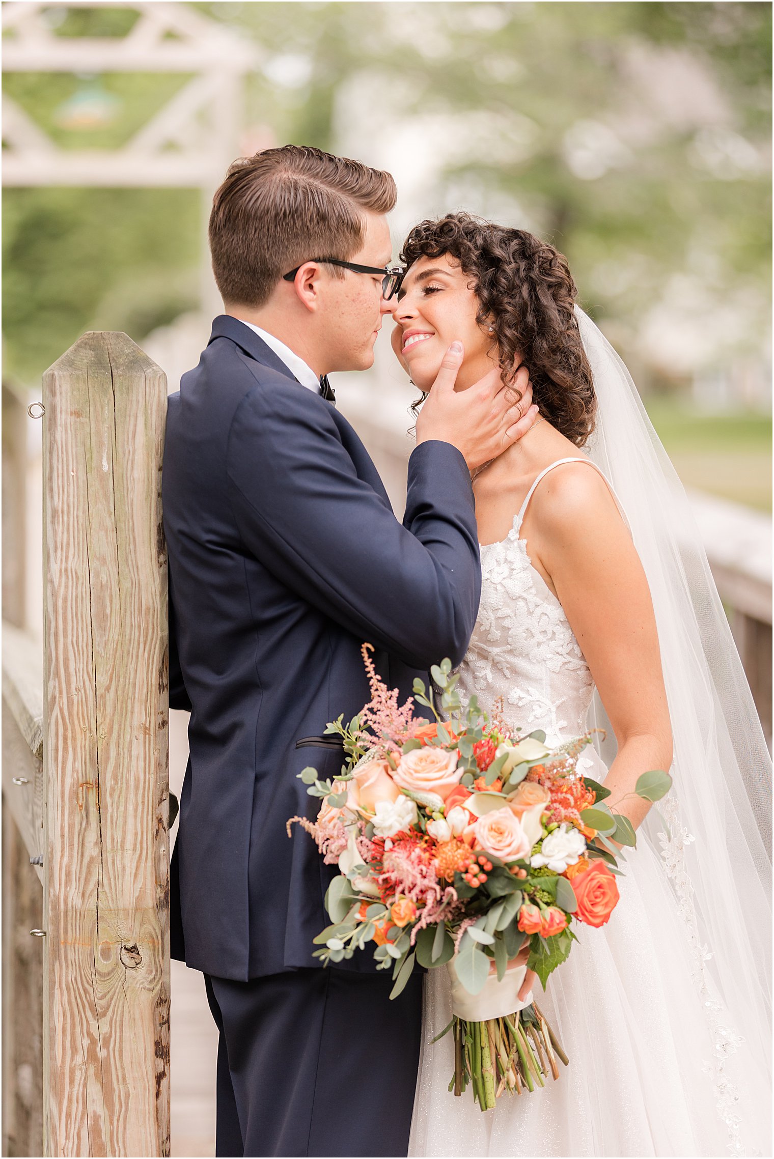 groom holds bride's chin leaning for kiss during NJ wedding day