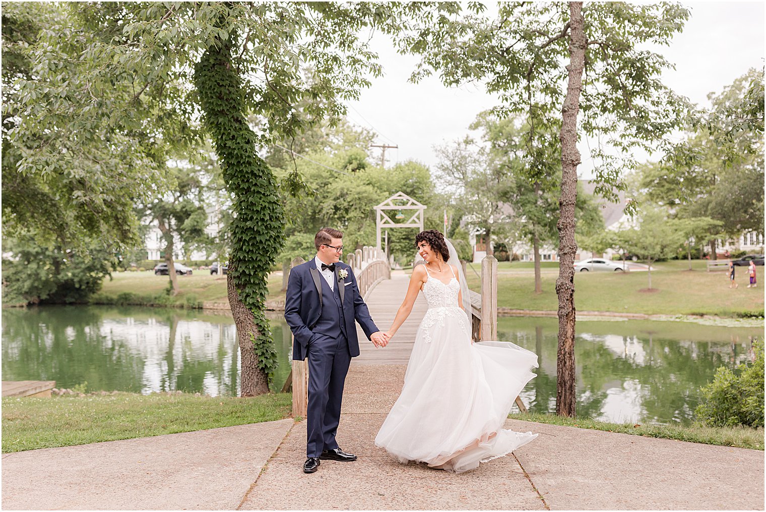 bride turns showing off wedding dress with groom at The Mill Lakeside Manor