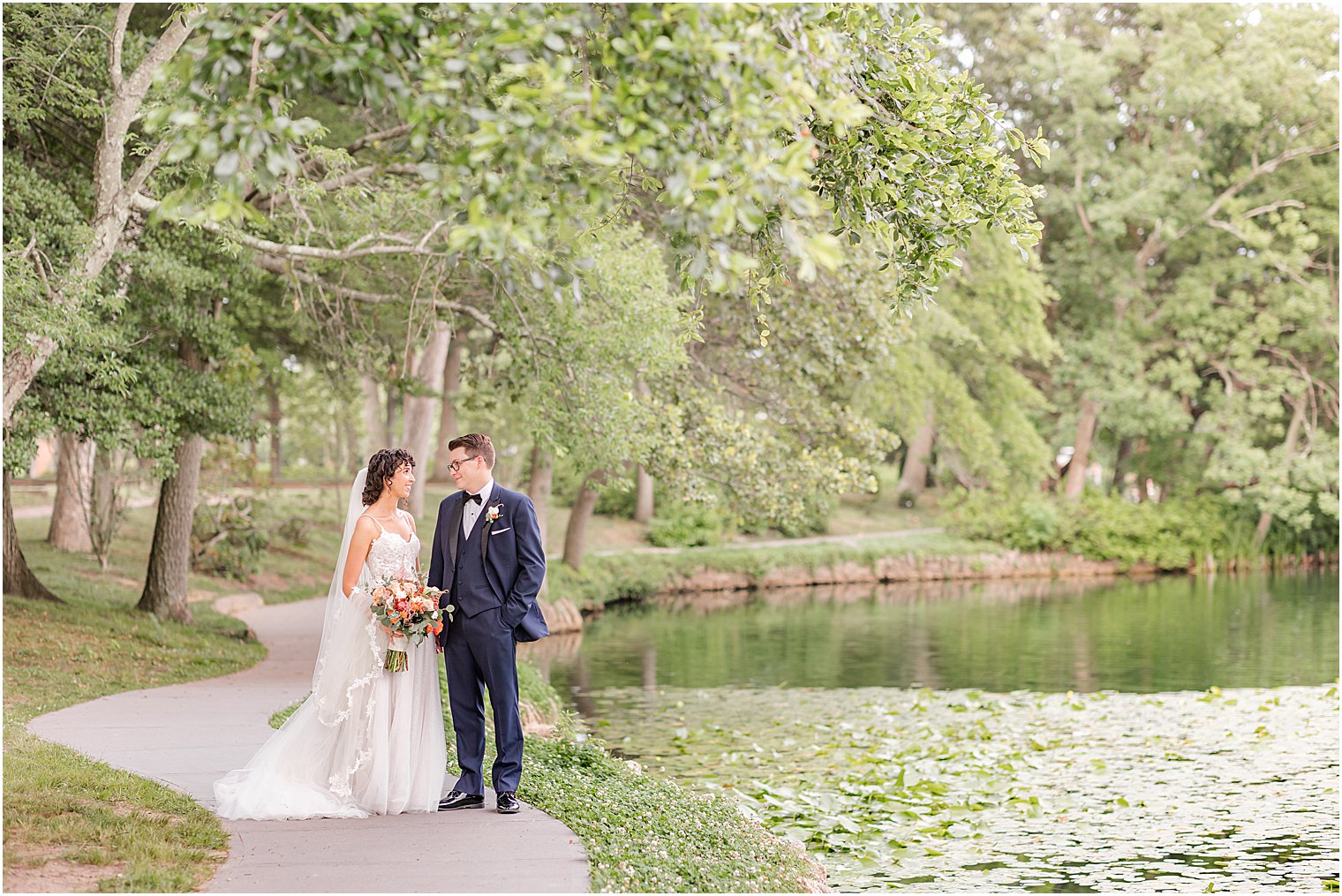 newlyweds walk along pond in New Jersey