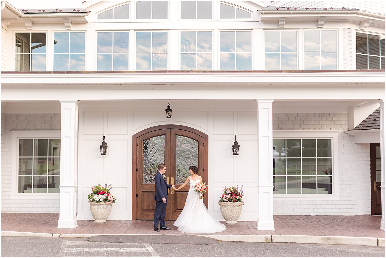 newlyweds walk by wooden doors at The Mill Lakeside Manor