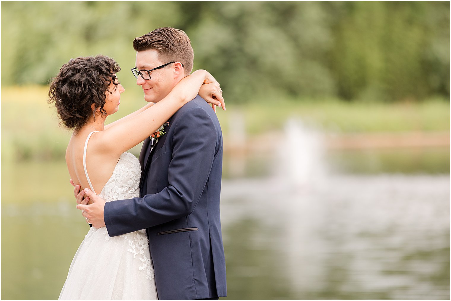bride and groom hug on dock at The Mill Lakeside Manor