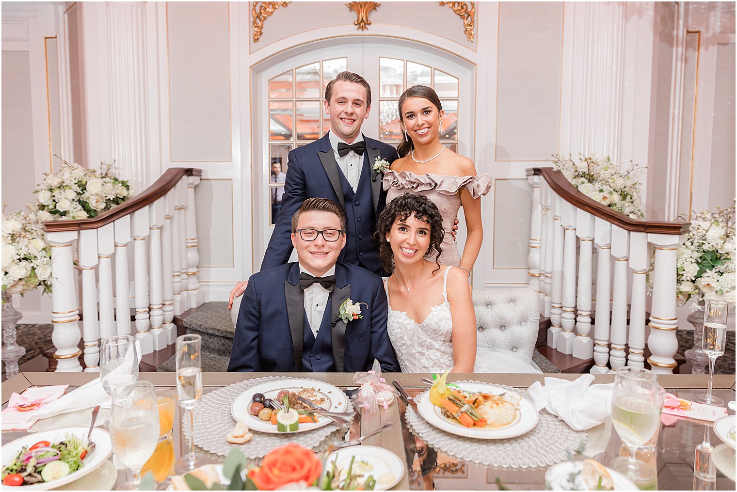 newlyweds sit with maid of honor and best man during Spring Lake NJ wedding reception