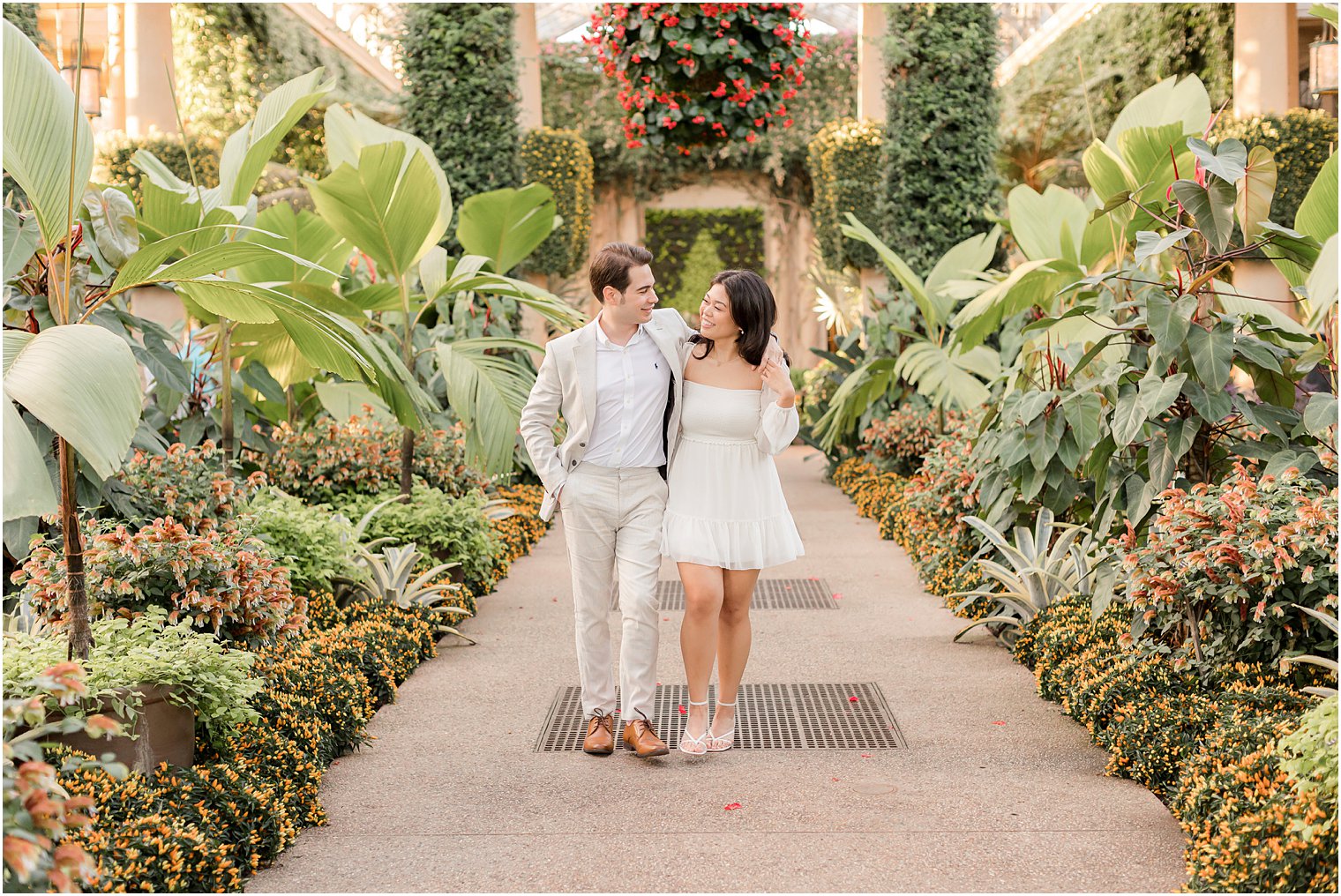 engaged couple walks down rows of plants at Longwood Gardens