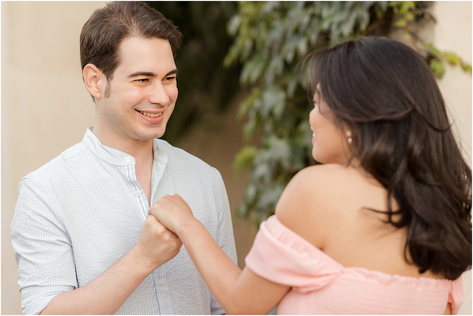 couple smiles together during portraits in Longwood Gardens