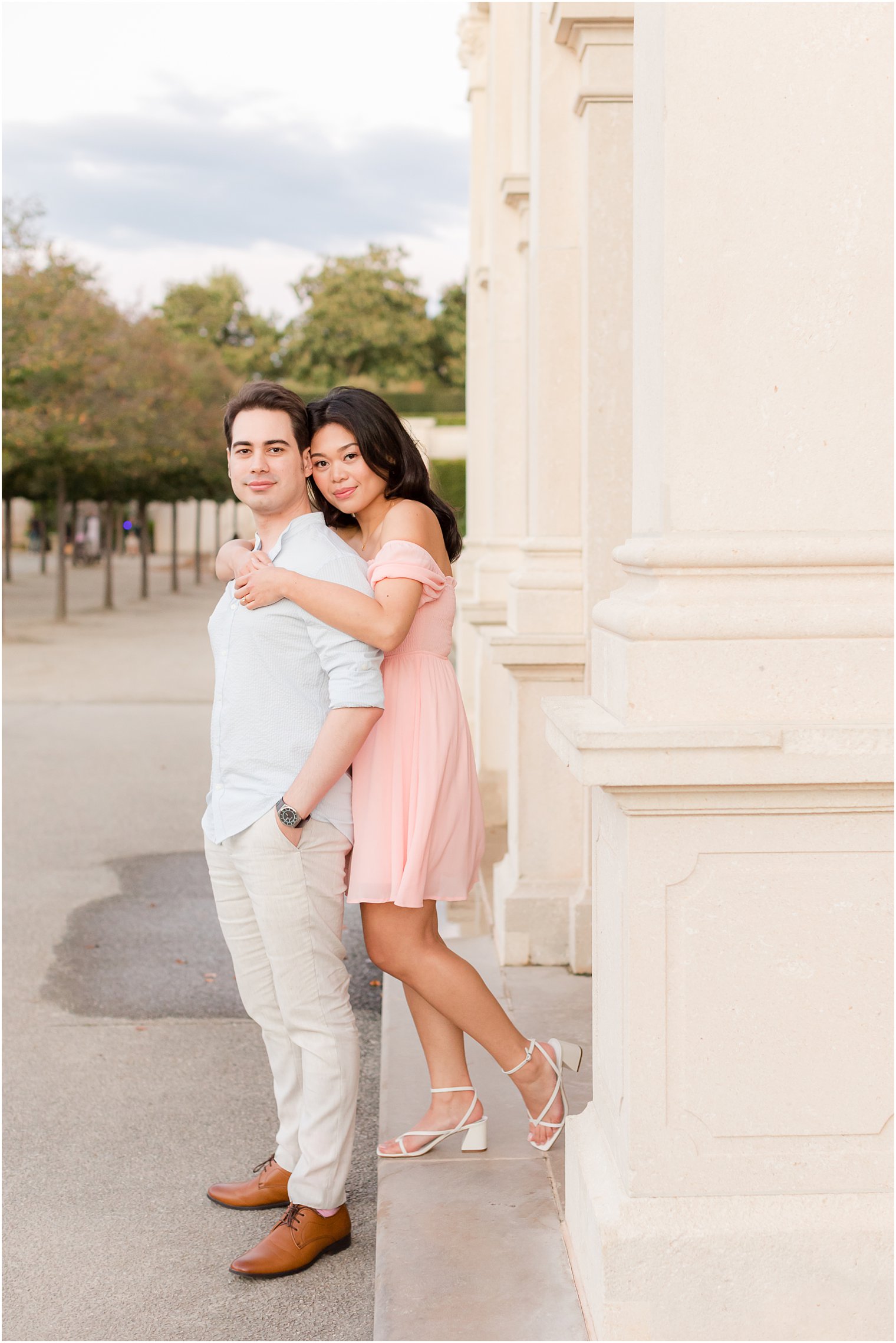 woman hugs fiancee from behind during portraits at Longwood Gardens