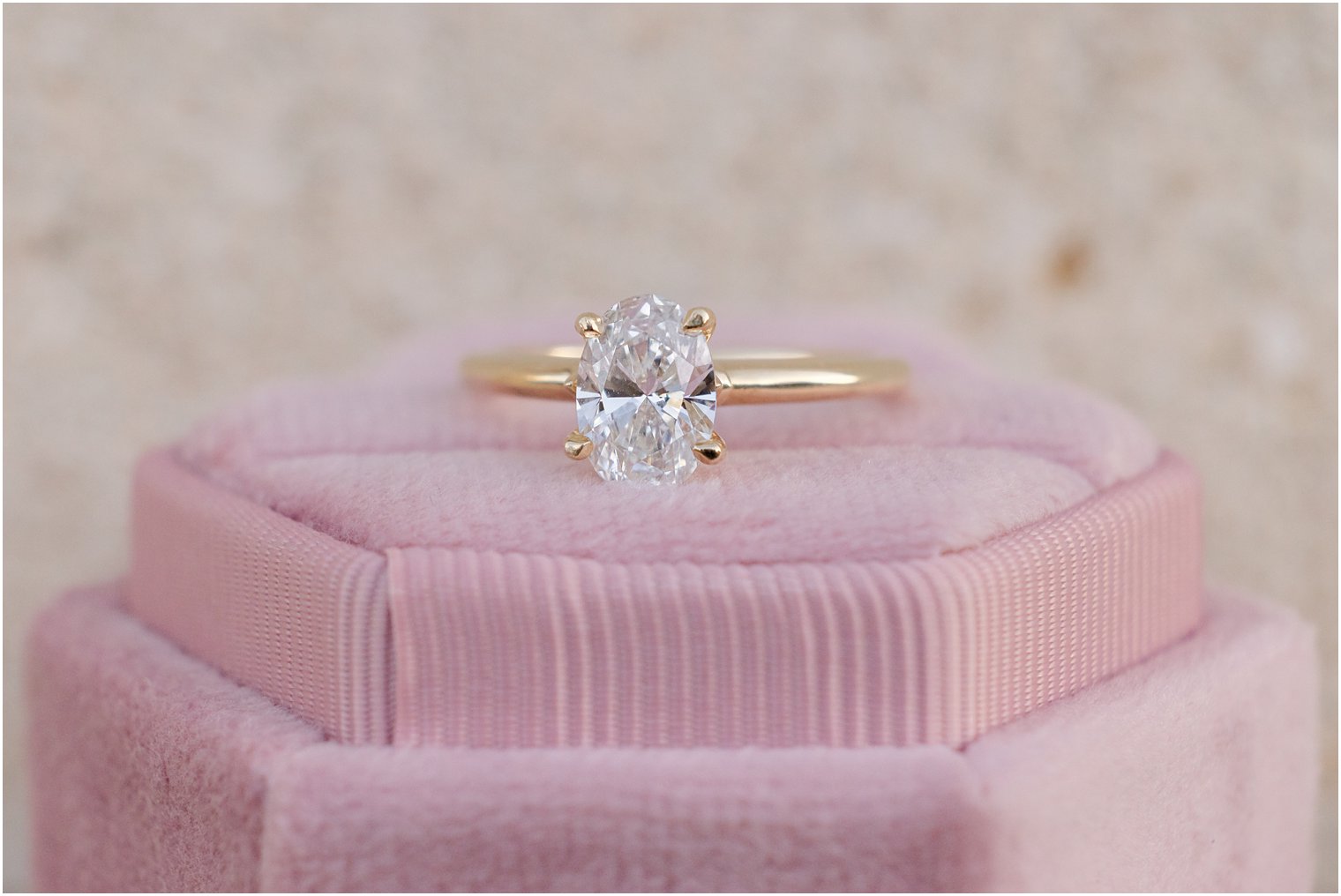 diamond ring rests on pink ring box