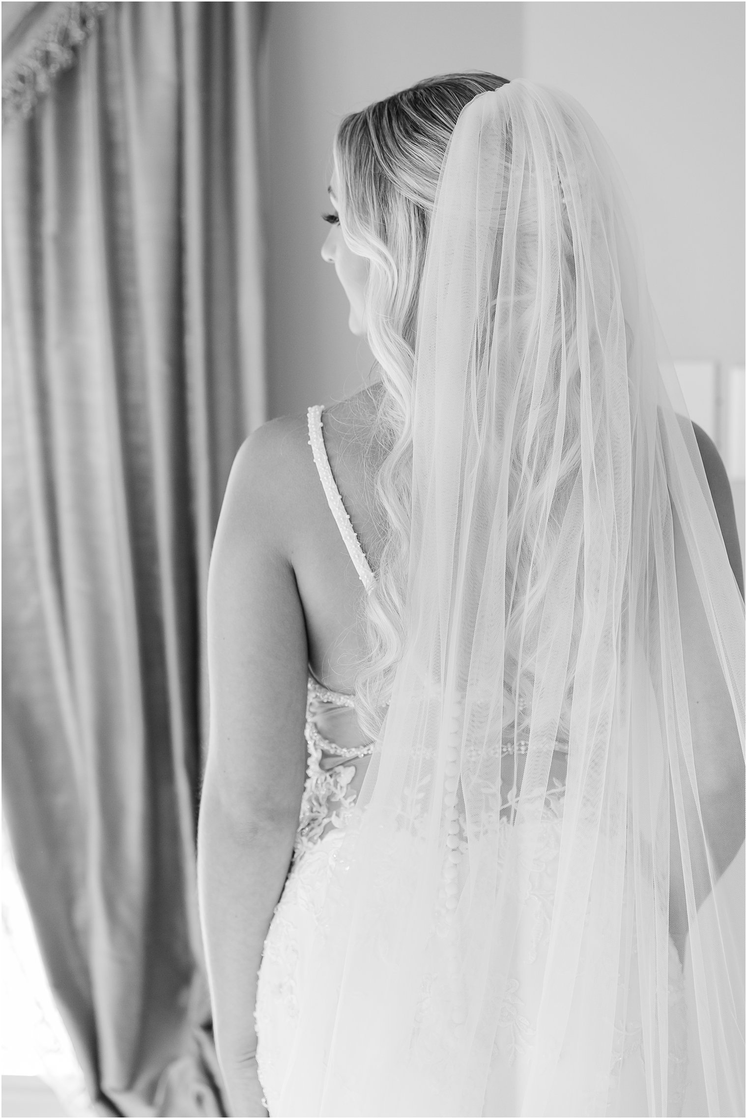 black and white portrait of back of wedding gown on bride