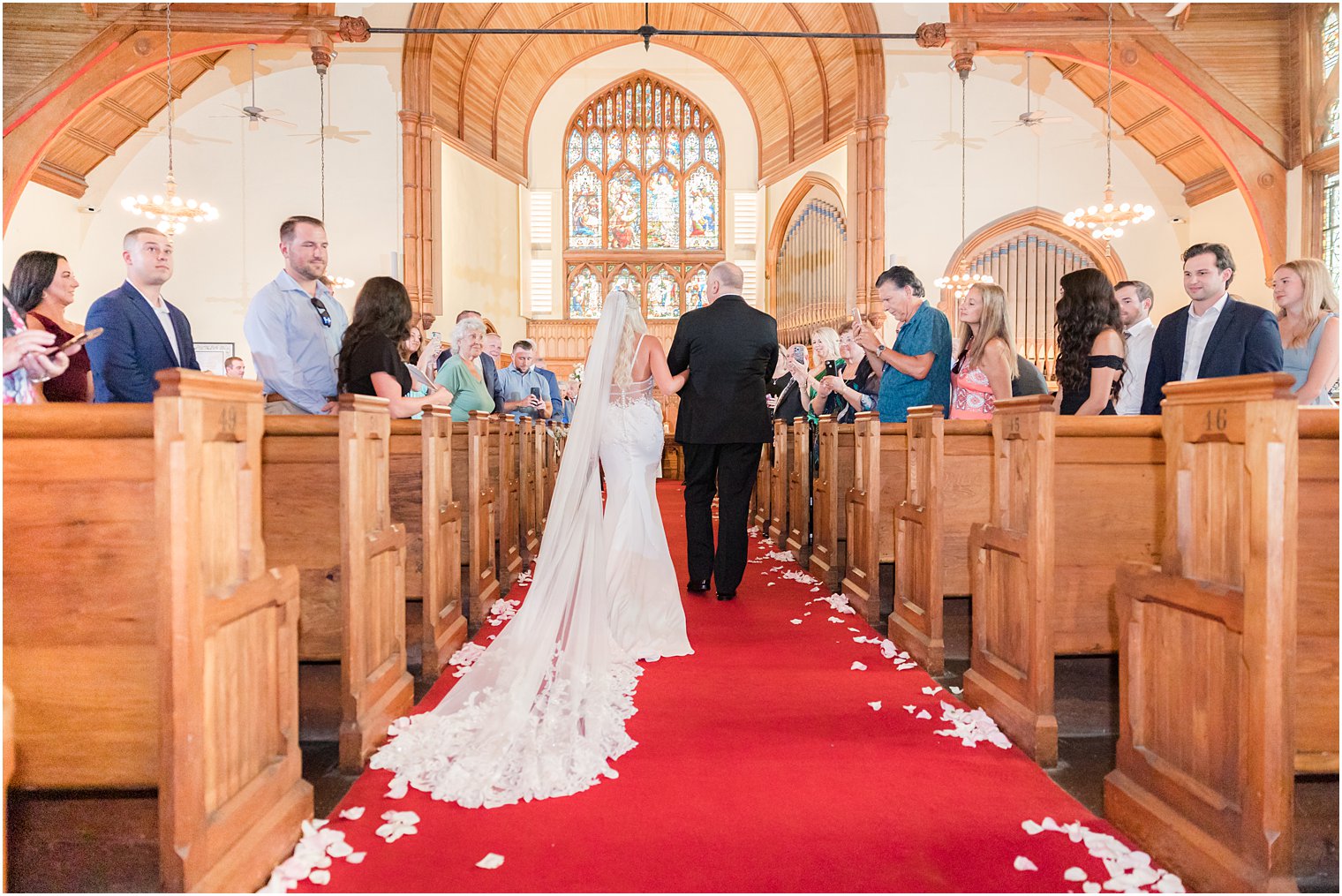 bride walks down aisle before traditional church wedding in New Jersey