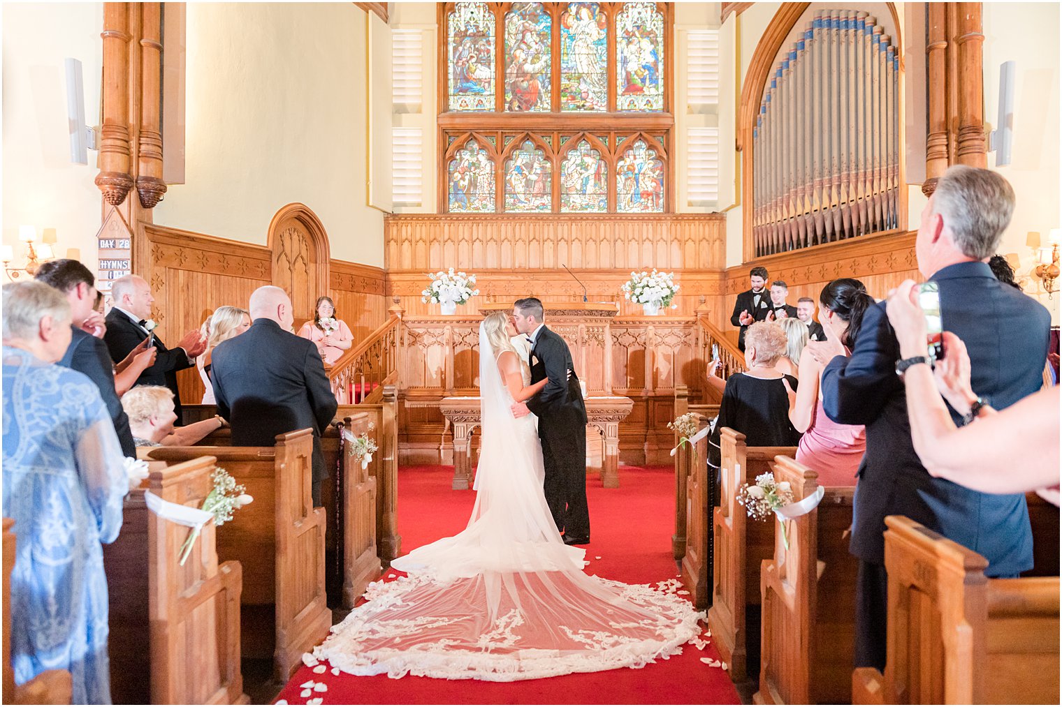 newlyweds kiss by alter after traditional church wedding in New Jersey