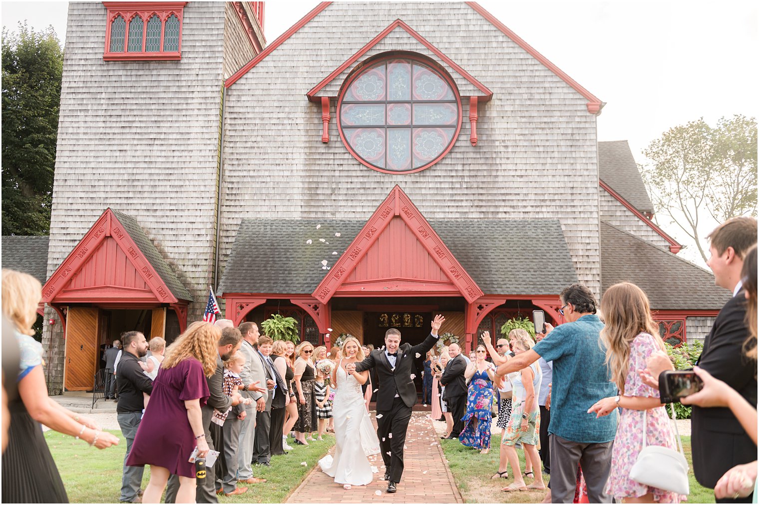 bride and groom walk through guests outside church