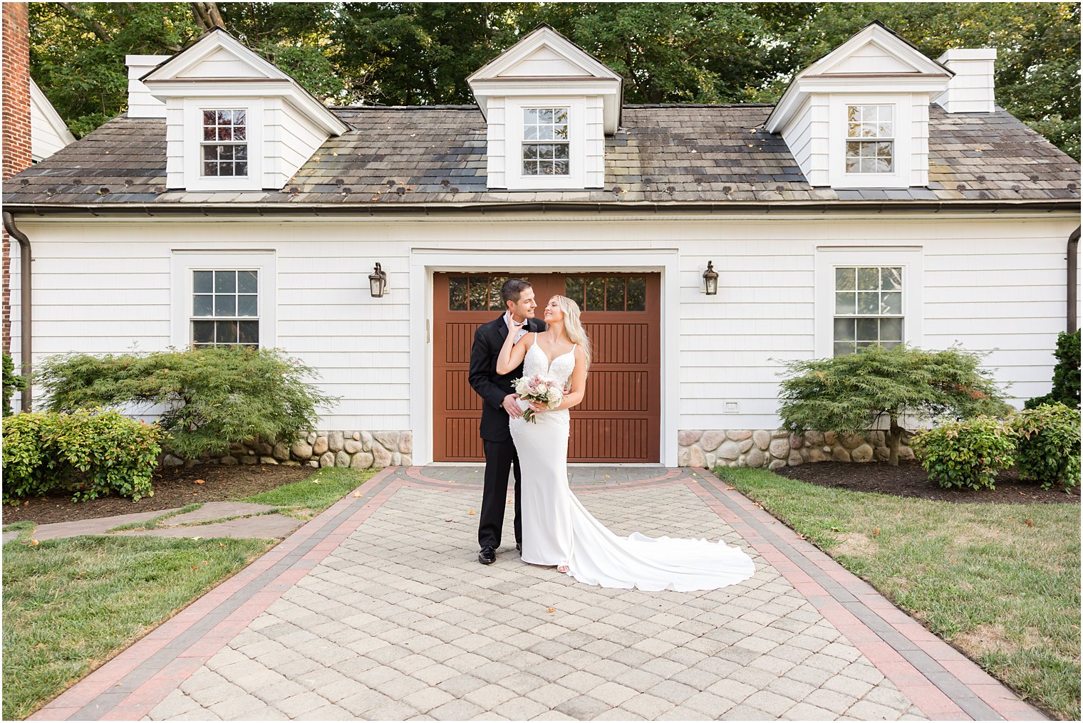 bride and groom hug on brick walkway at The English Manor