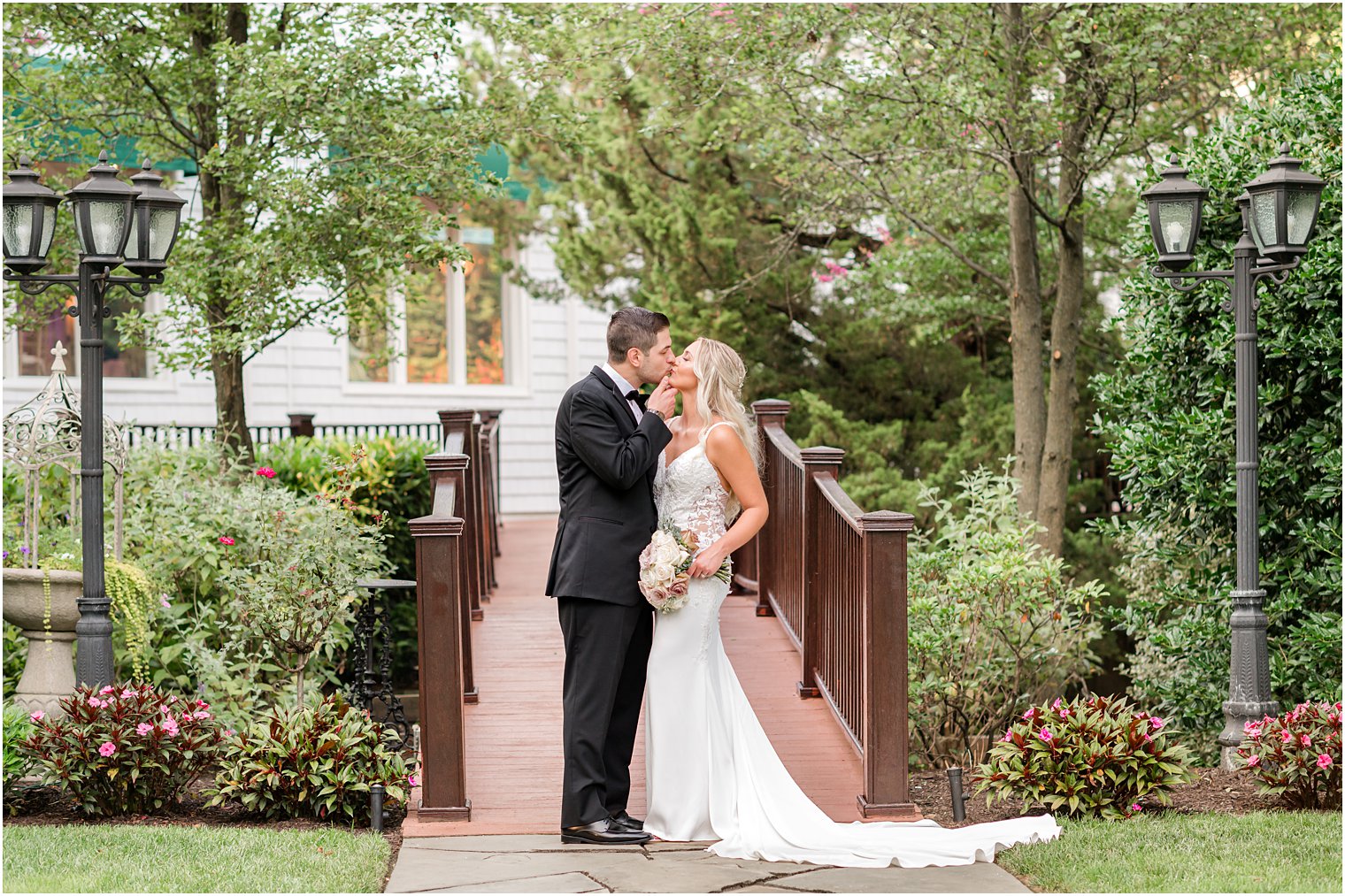 bride and groom kiss on wooden bridge at The English Manor