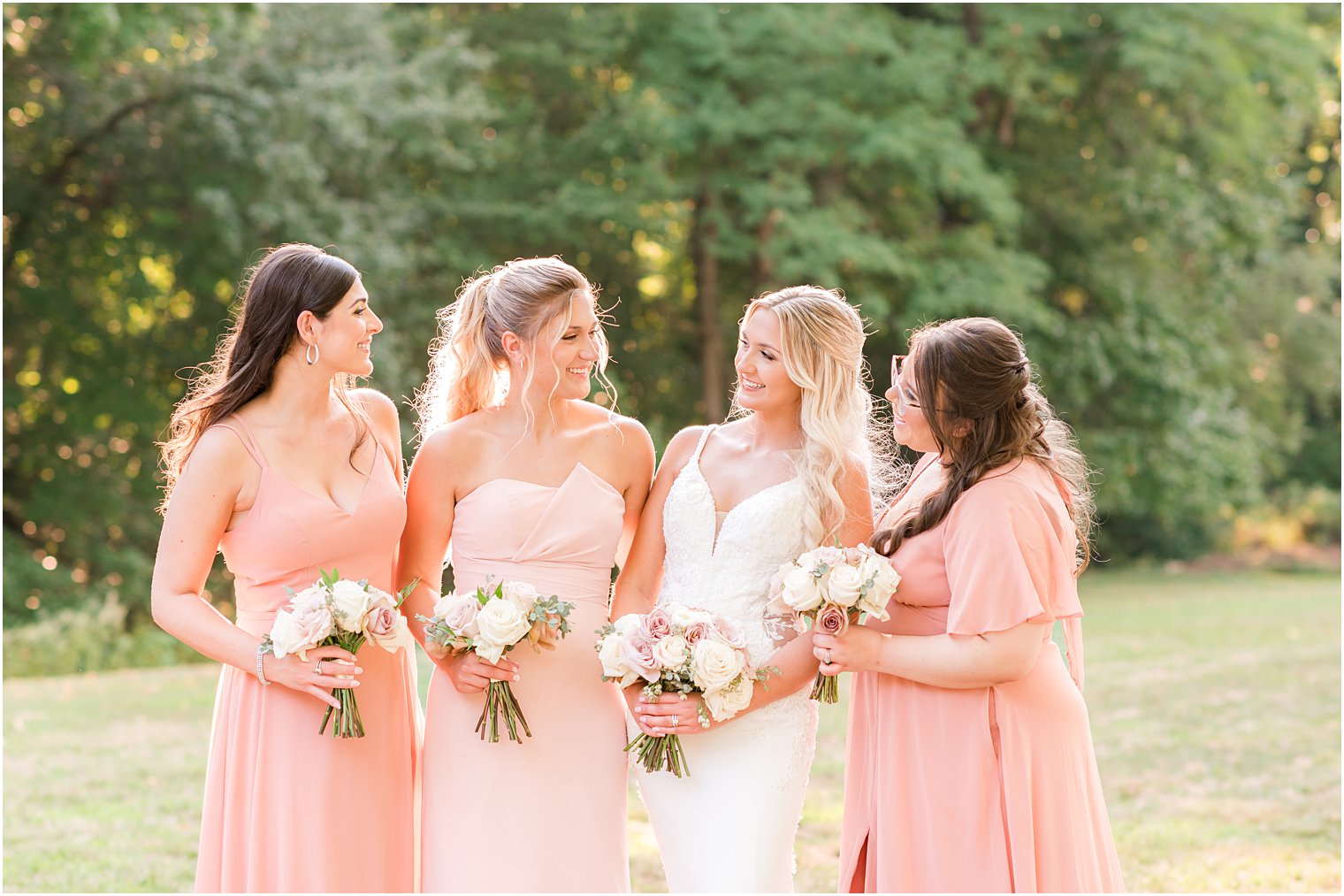 bride smiles at bridesmaids in pink gowns at The English Manor