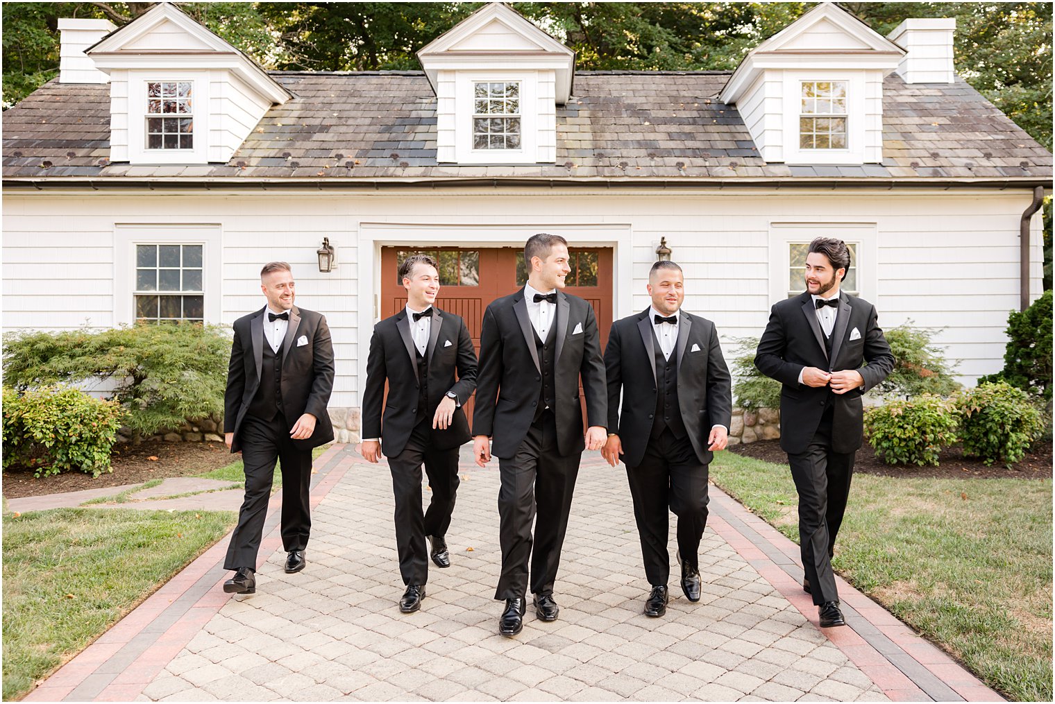 groom walks with groomsmen outside The English Manor