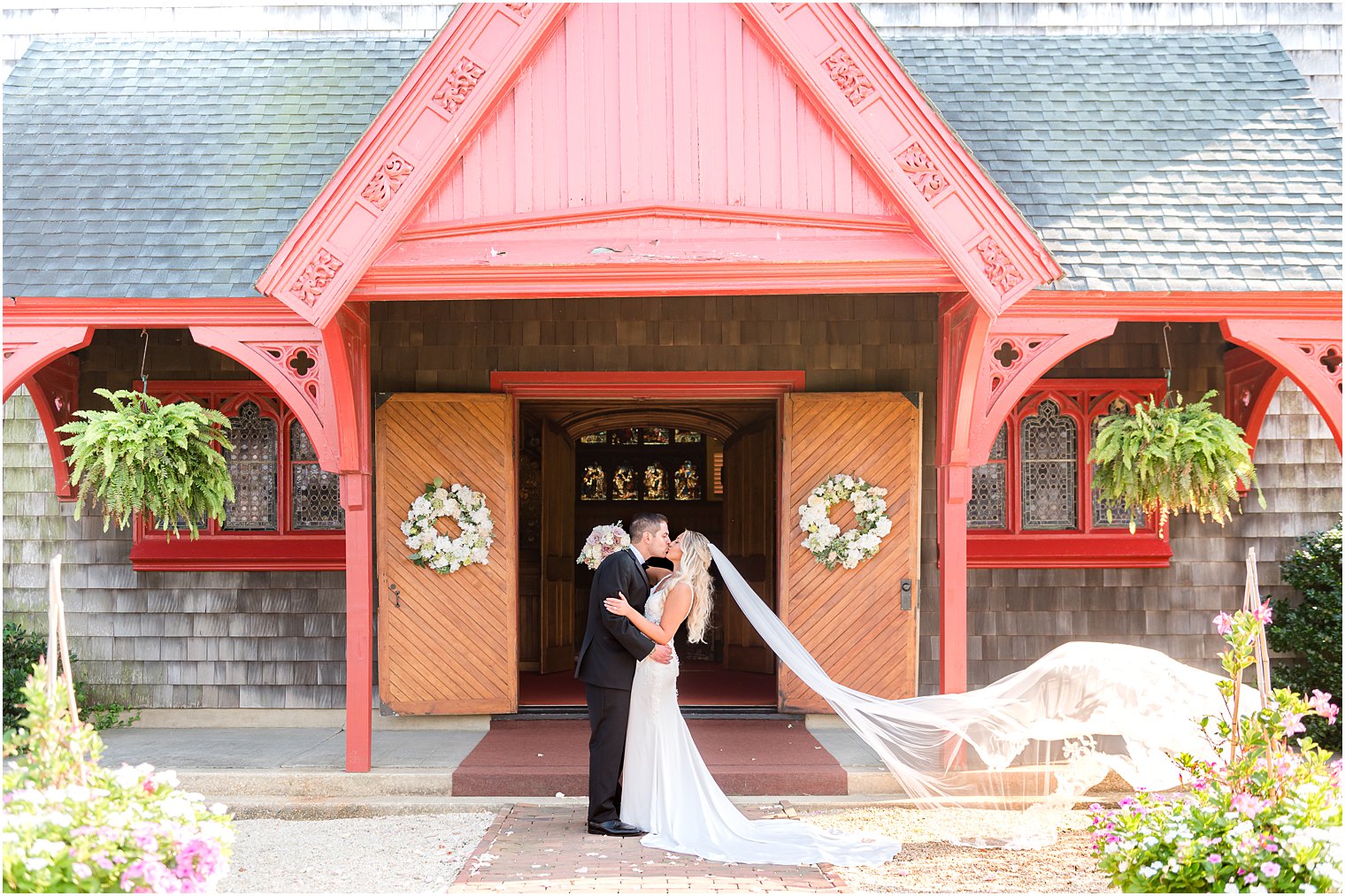 newlyweds kiss under red awning at NJ church