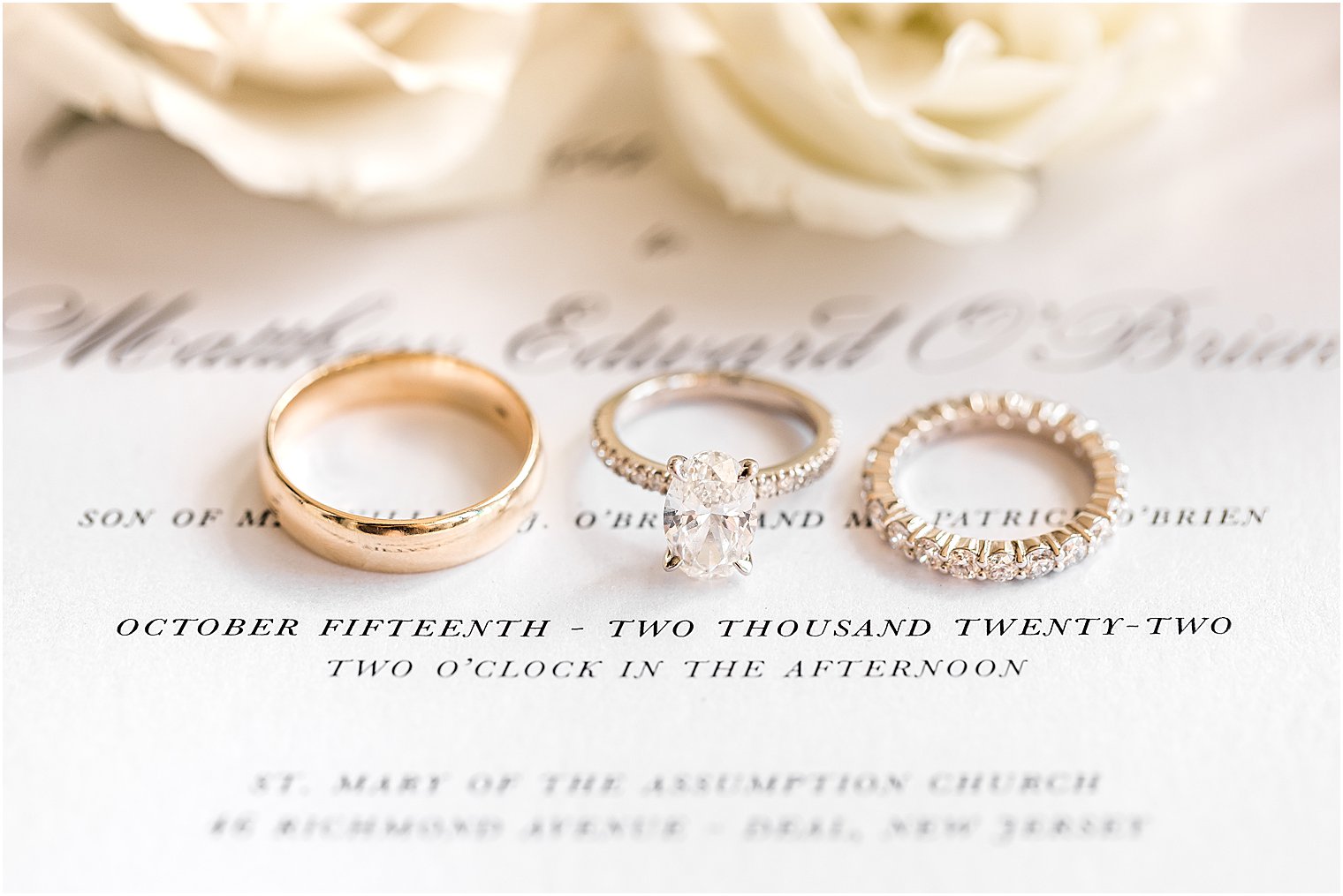 three wedding bands rest on classic invitation suite 