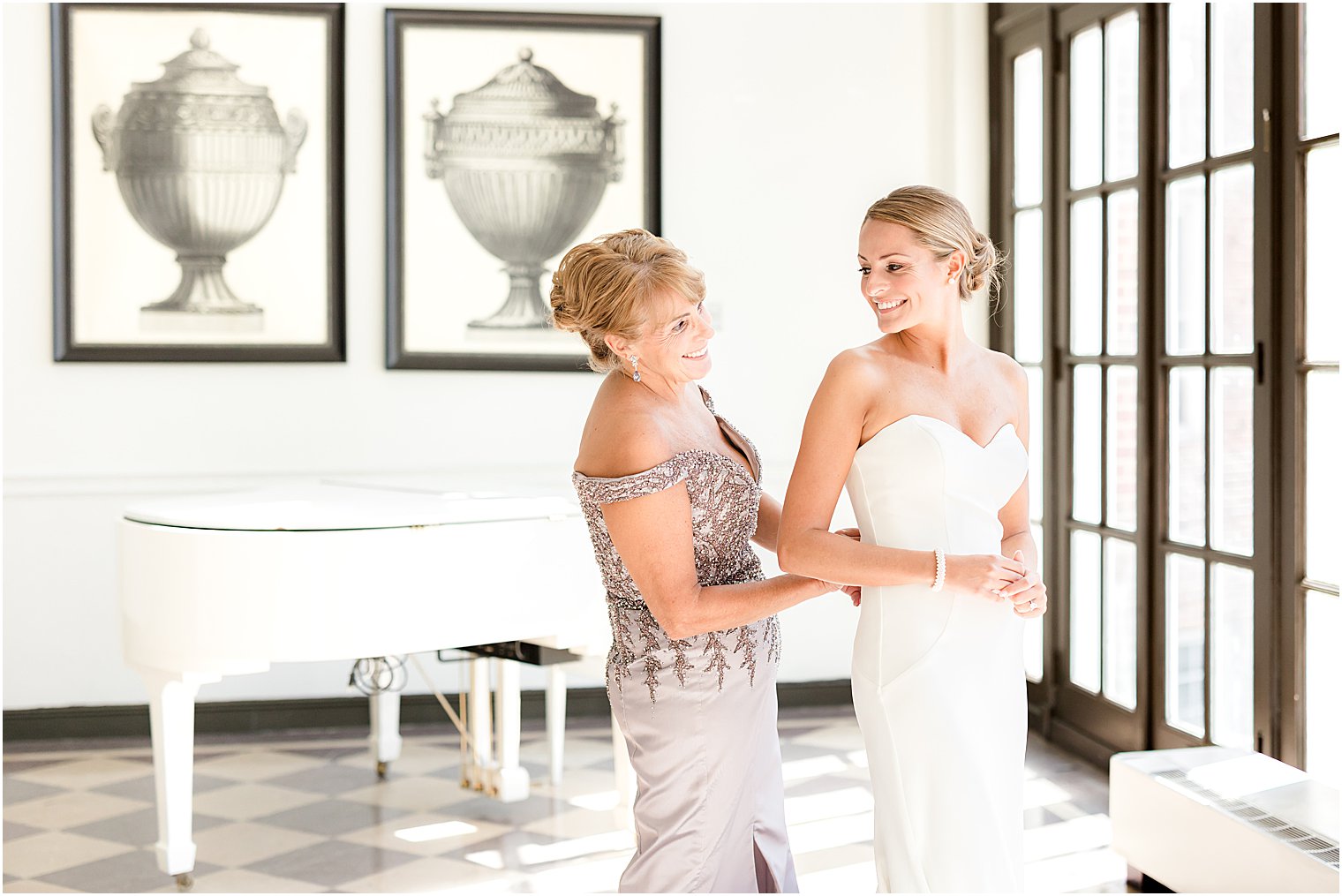 mother helps bride into wedding dress inside NJ wedding venue 