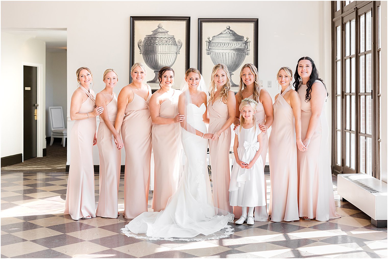 bride poses with bridesmaids in pink gowns in mezzanine at the Berkeley Oceanfront Hotel