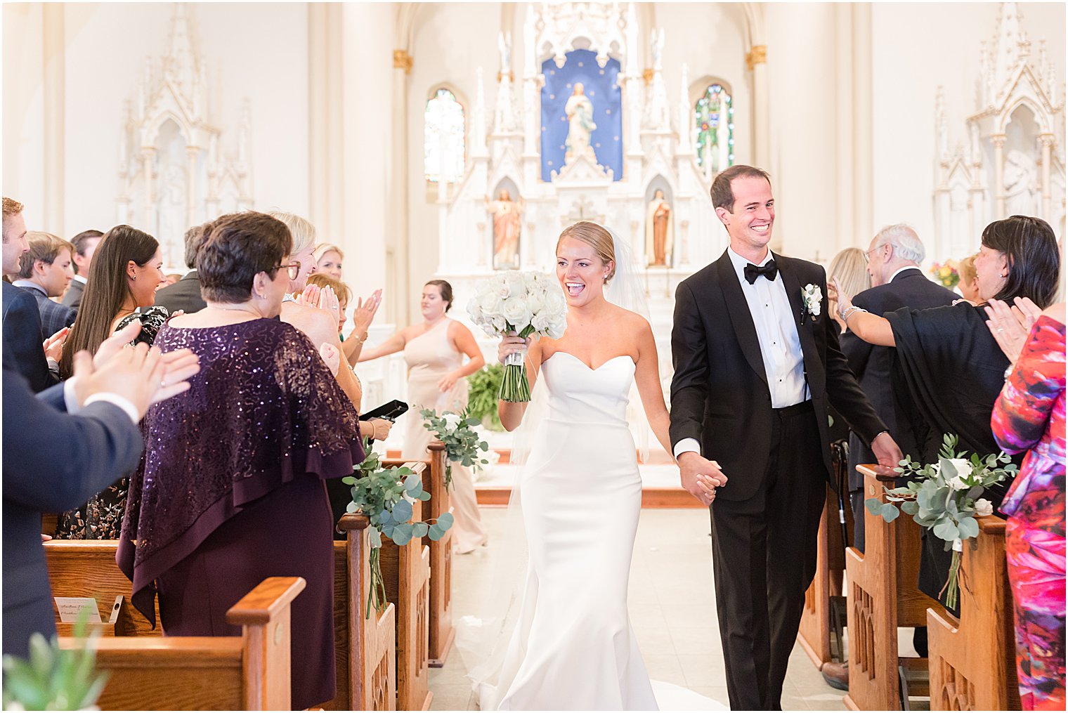 bride and groom walk up aisle after traditional church wedding at St. Mary's Catholic Church