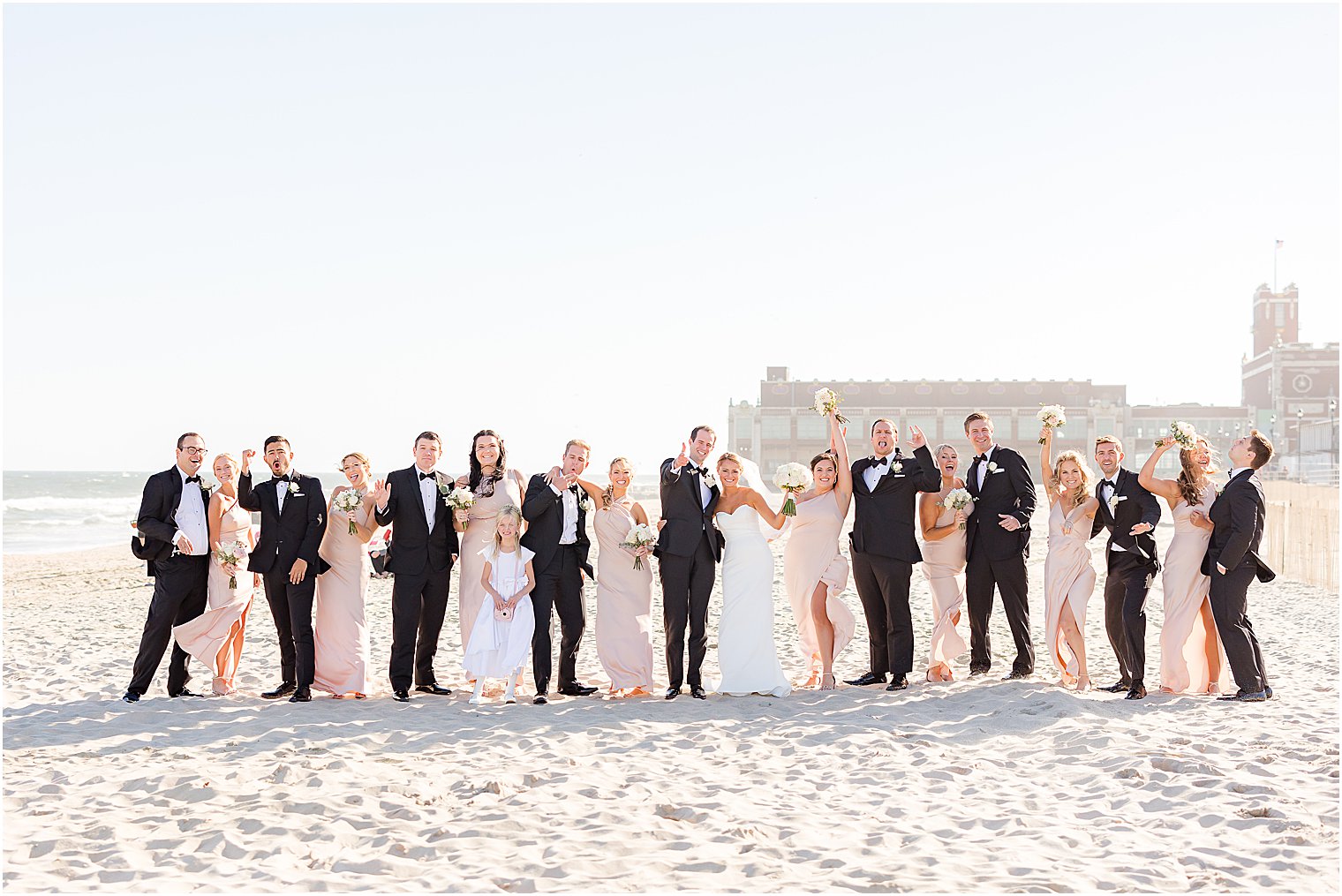 wedding party cheers with bride and groom at Asbury Park