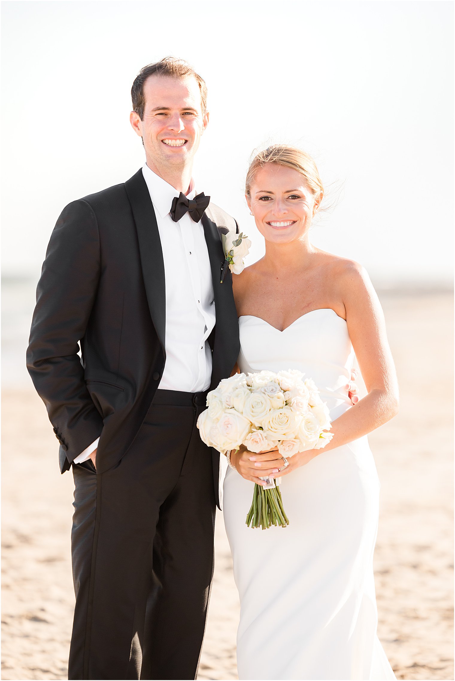 bride and groom stand together on beach at Asbury Park