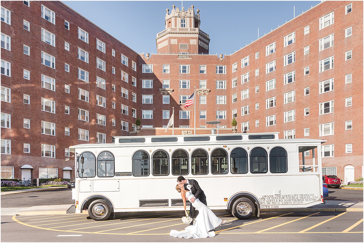 groom dips bride kissing her by white trolley outside the Berkeley Oceanfront Hotel 